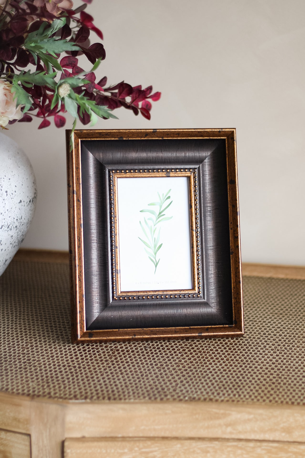 Framed artwork with a leaf design on a textured surface
