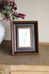 Framed artwork with a leaf design on a textured surface