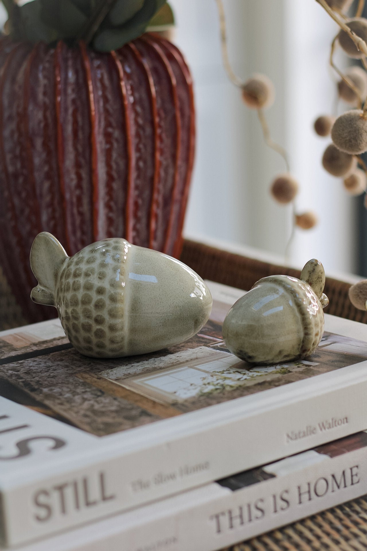 two glazed ceramic acorns on coffee table book