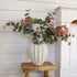 blush tipped faux eucalyptus stems in white ceramic vase for home decor