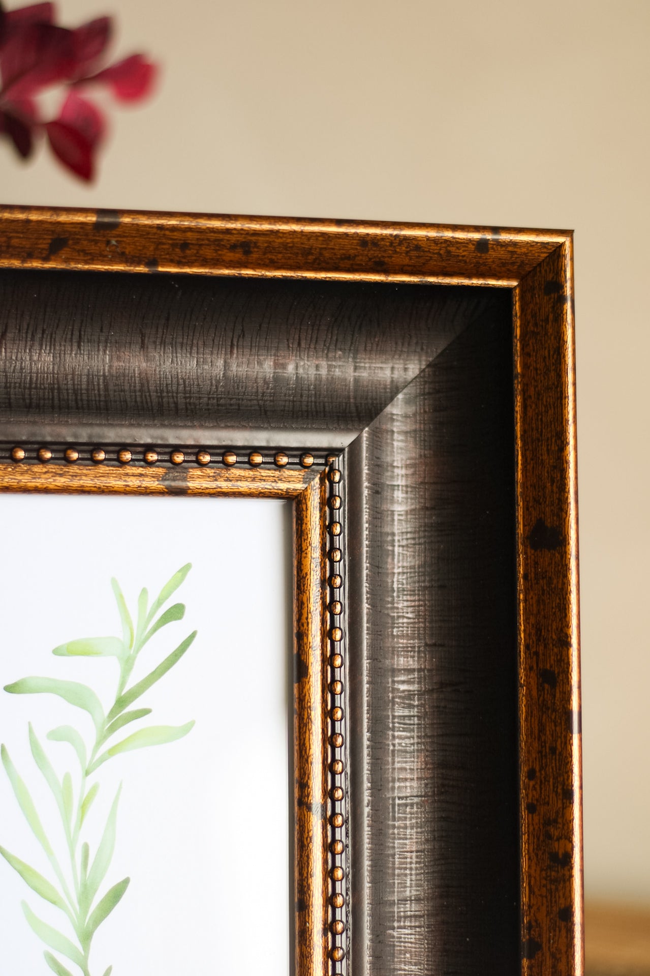 Close-up of an ornate gold picture frame with a blurred background