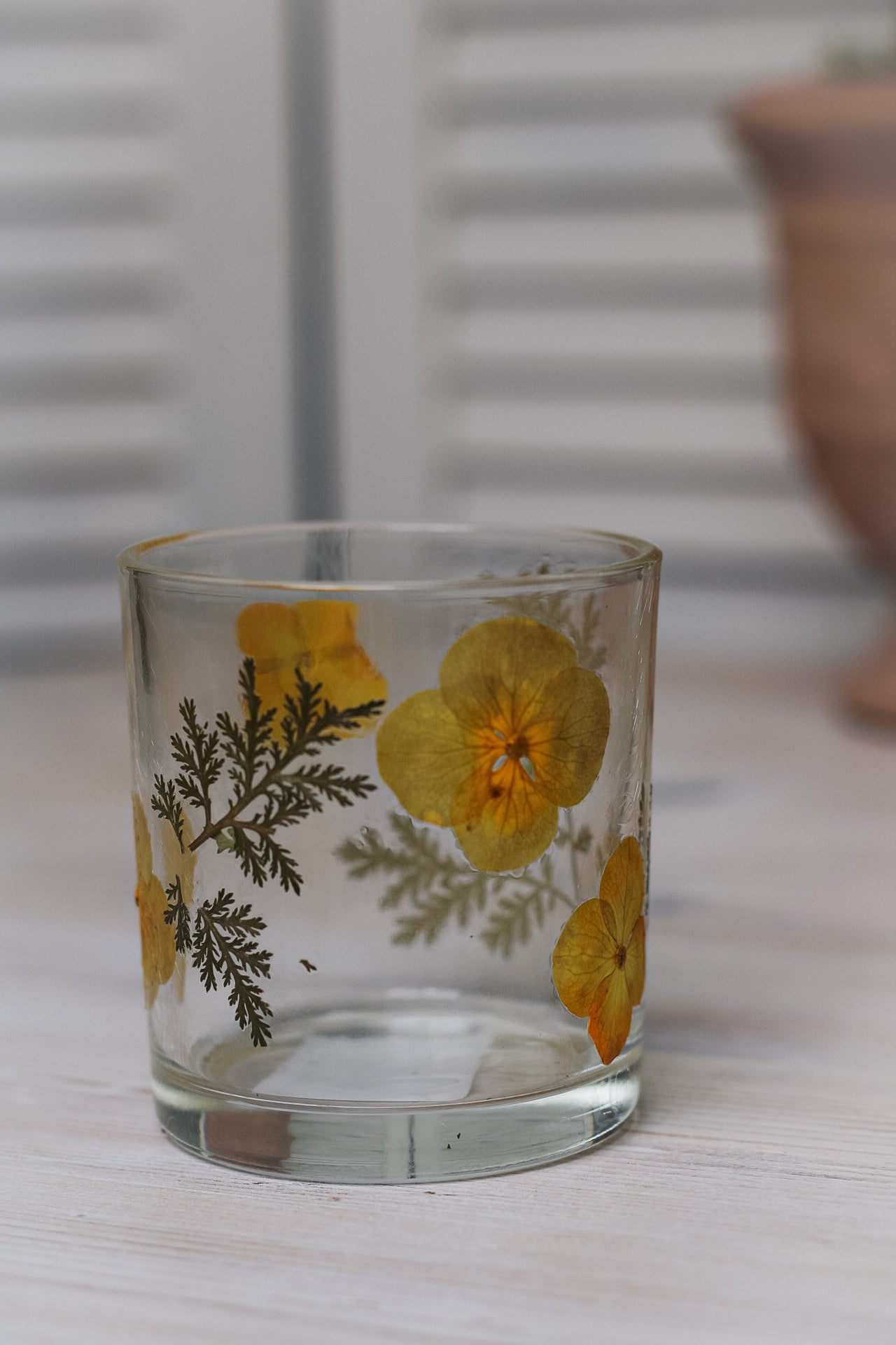 close up of glass tea light holders with yellow flowers