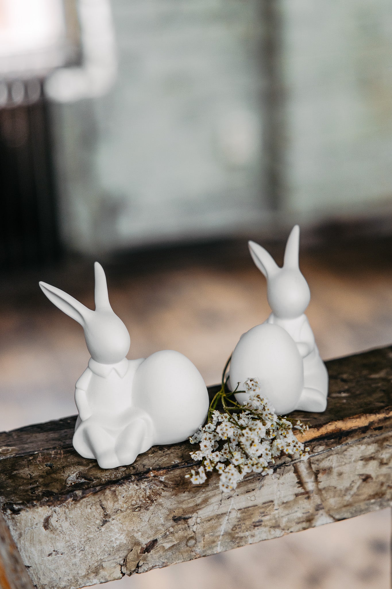 two matt white sitting bunnies with eggs