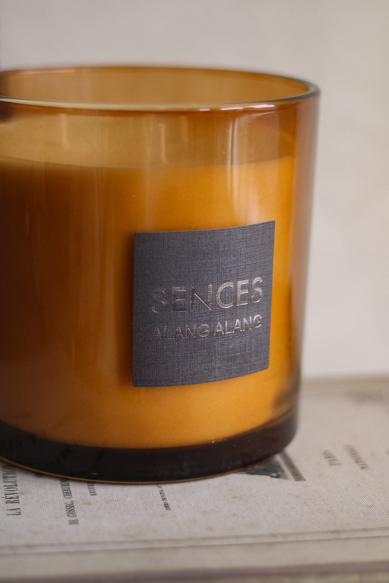Brown candle with a label on a surface
