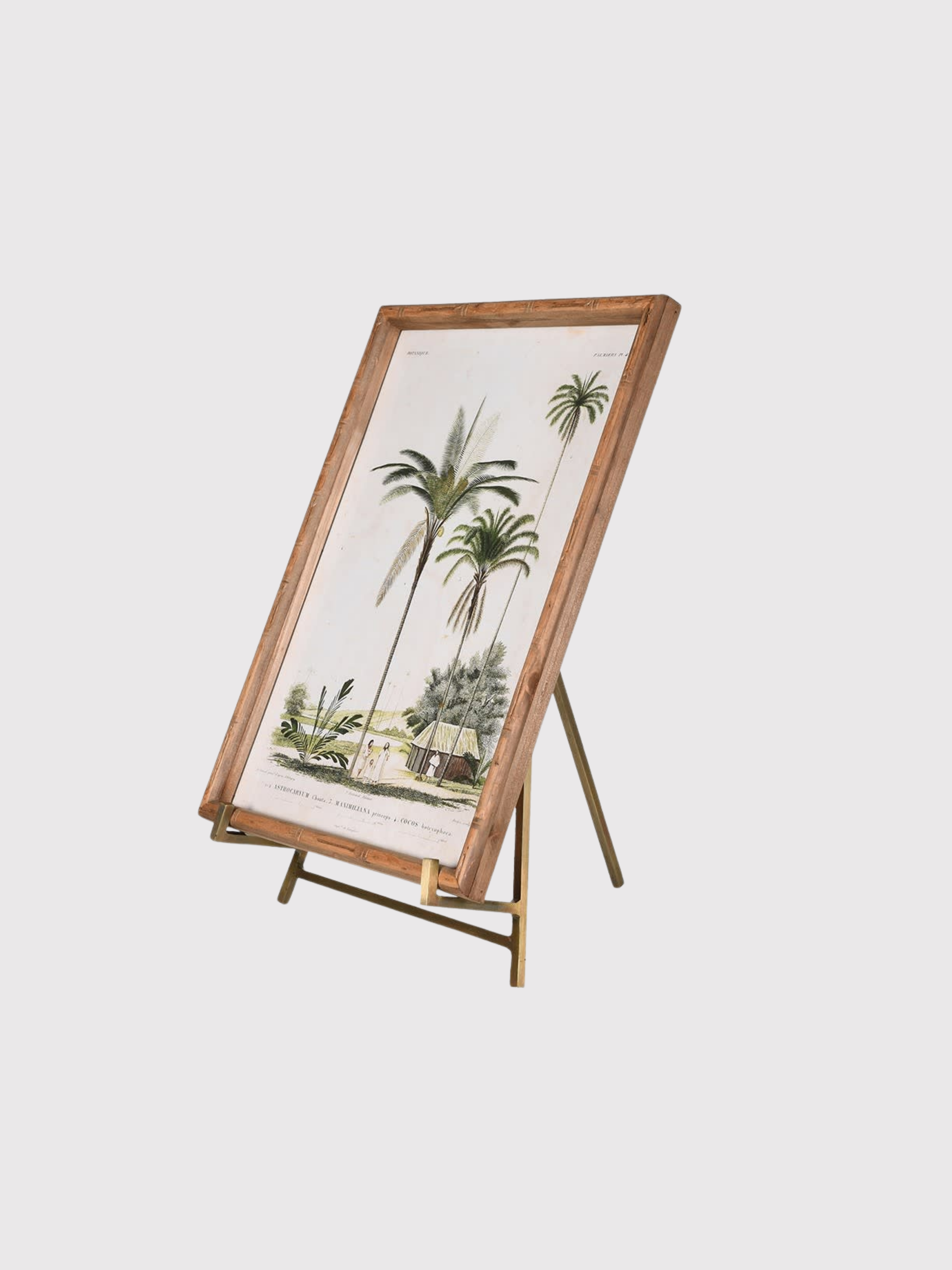 Framed artwork of palm trees on a antique brass easel stand against a white background
