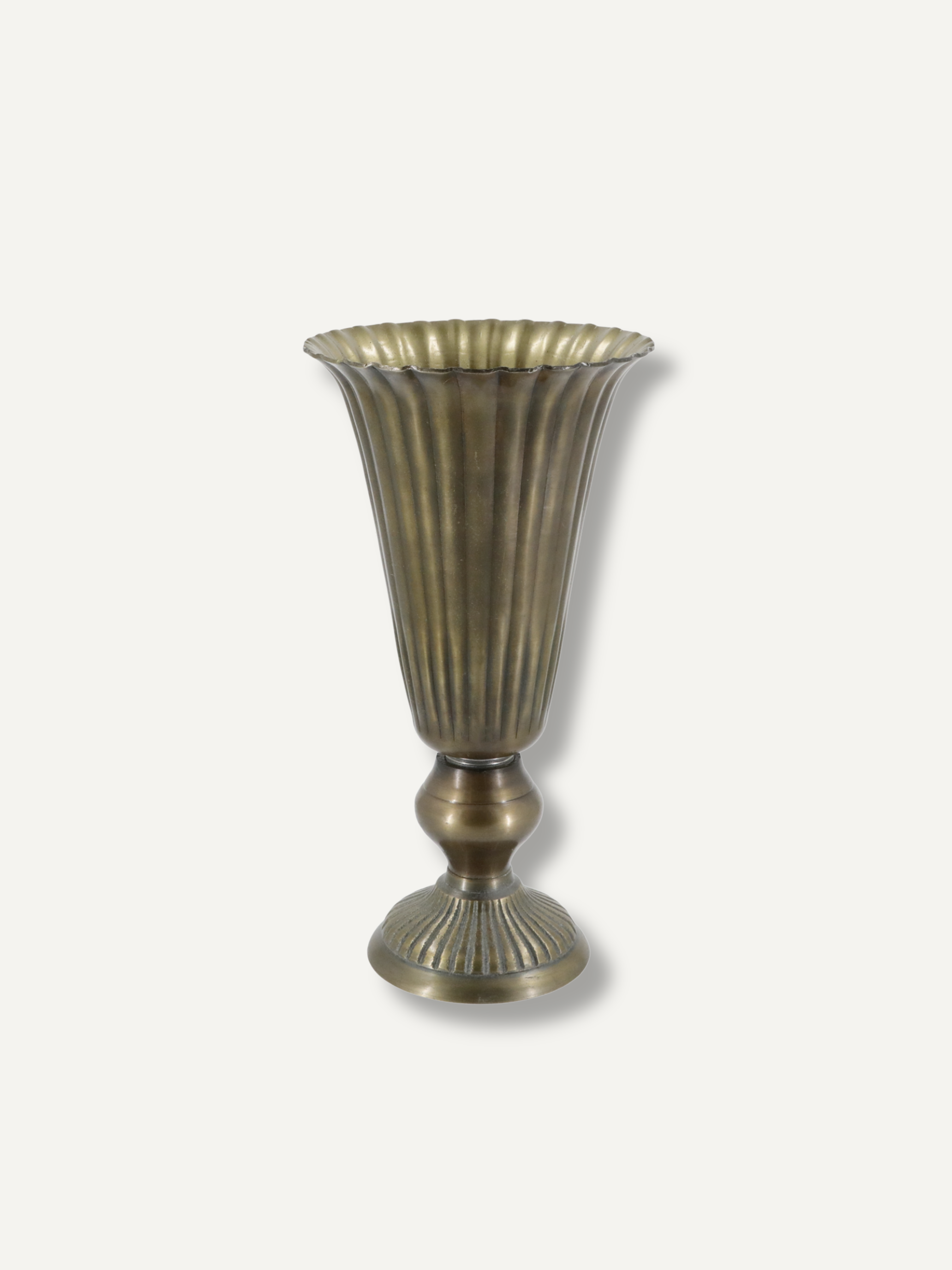 A vintage-style fluted metal vase with a flared rim and pedestal base, finished in an antique bronze or brass tone, shown against a plain light gray background.