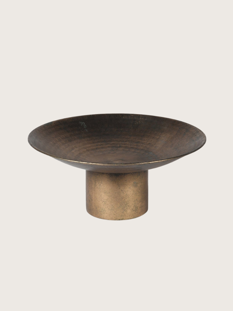 Bronze-colored bowl on a stand against a light gray background