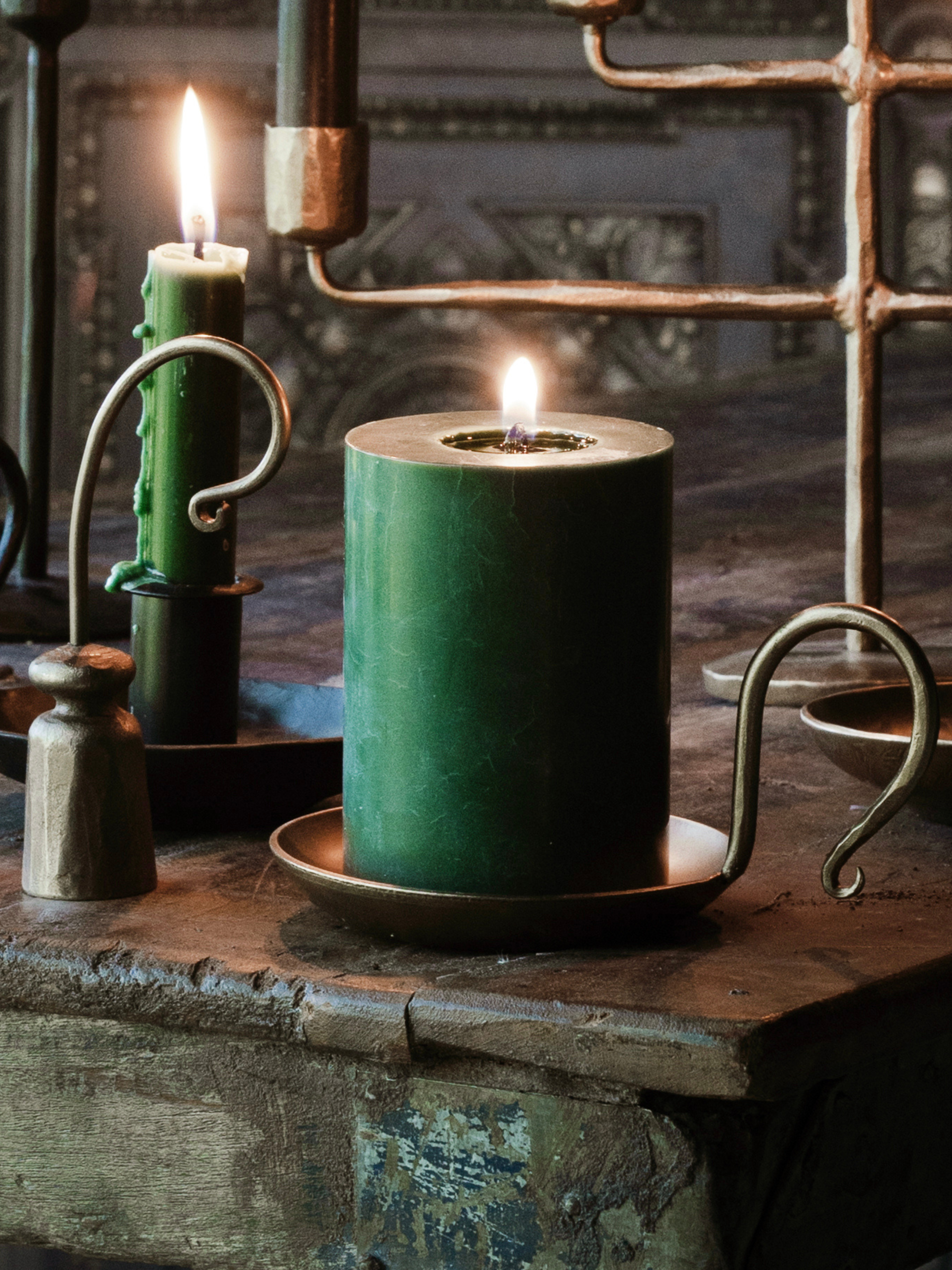Green candle on a rustic gold candle holder with vintage-style metal elements, lovely piece for home decor tray styling