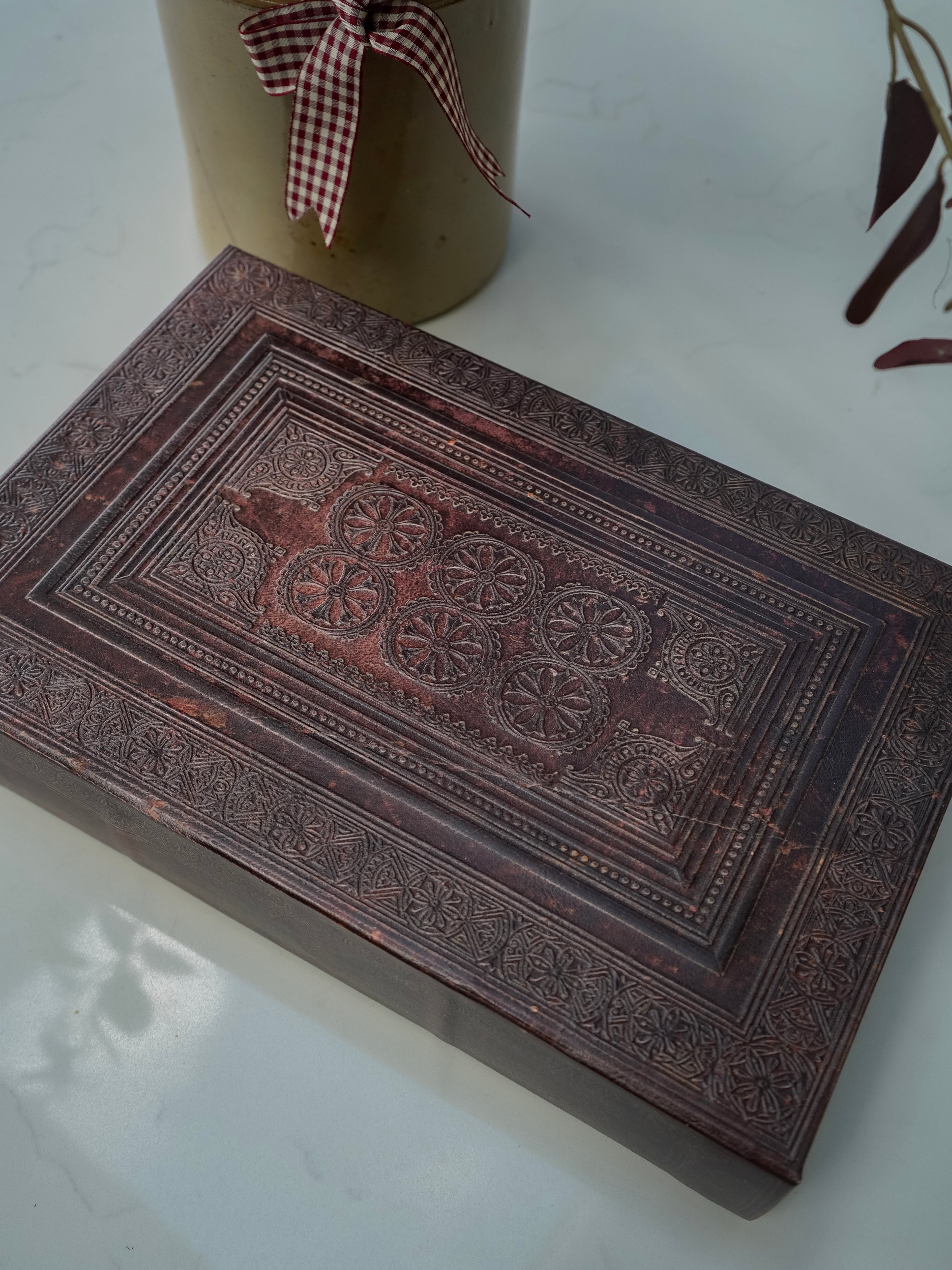 Decorative storage book box with intricate carvings on a white surface