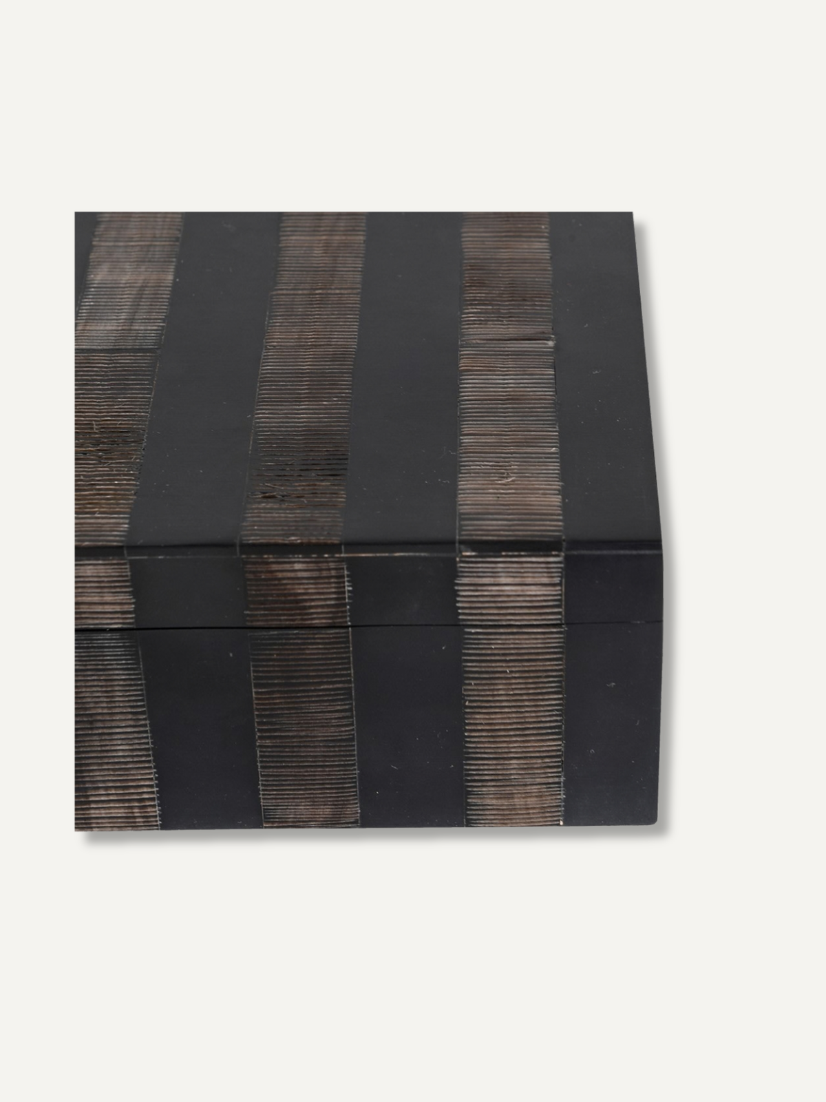 A rectangular black lacquered box with vertical dark brown wooden slat accents, photographed from an angled top-down view on a light off-white background.