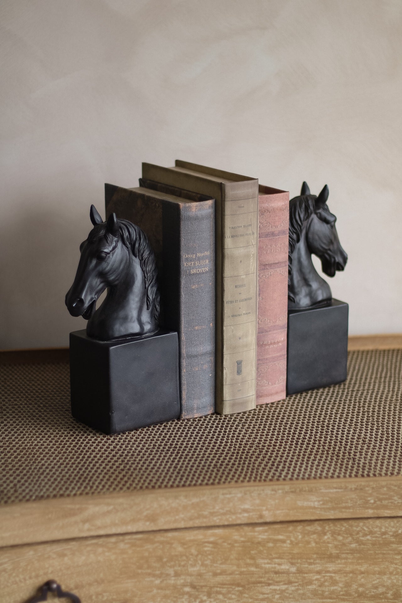 Bookends with horse heads on a textured surface
