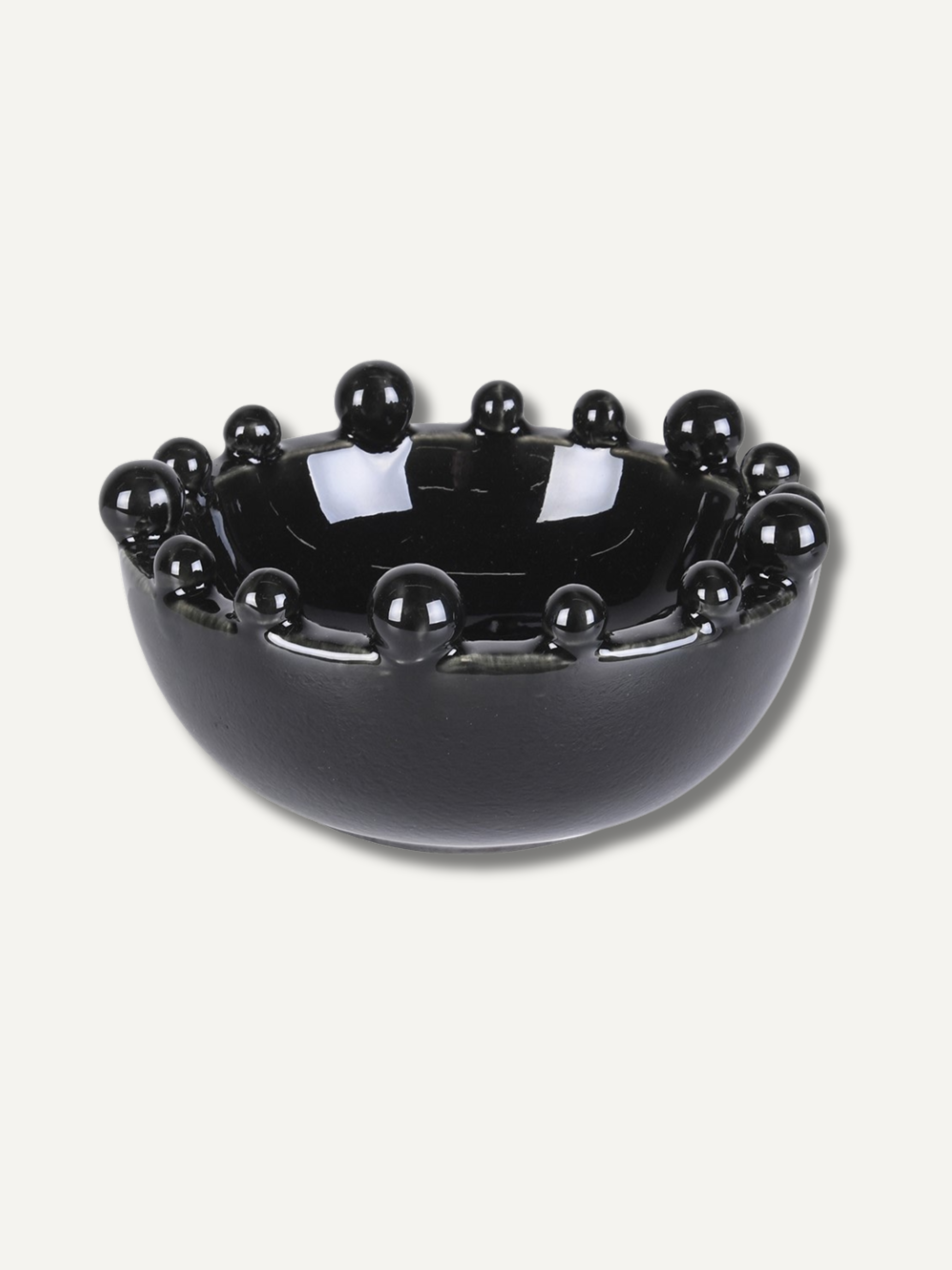 Black decorative bowl with bobbles embellishments on a white background