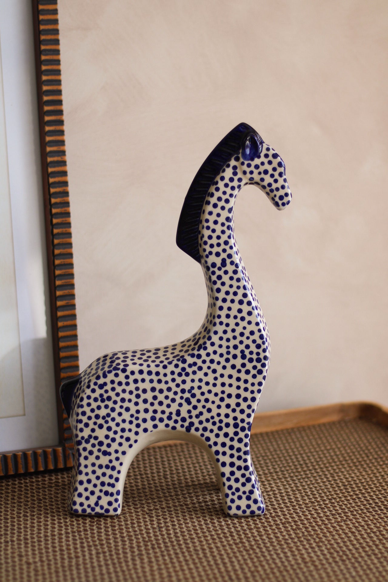 Decorative giraffe figurine with blue and white pattern on a beige background