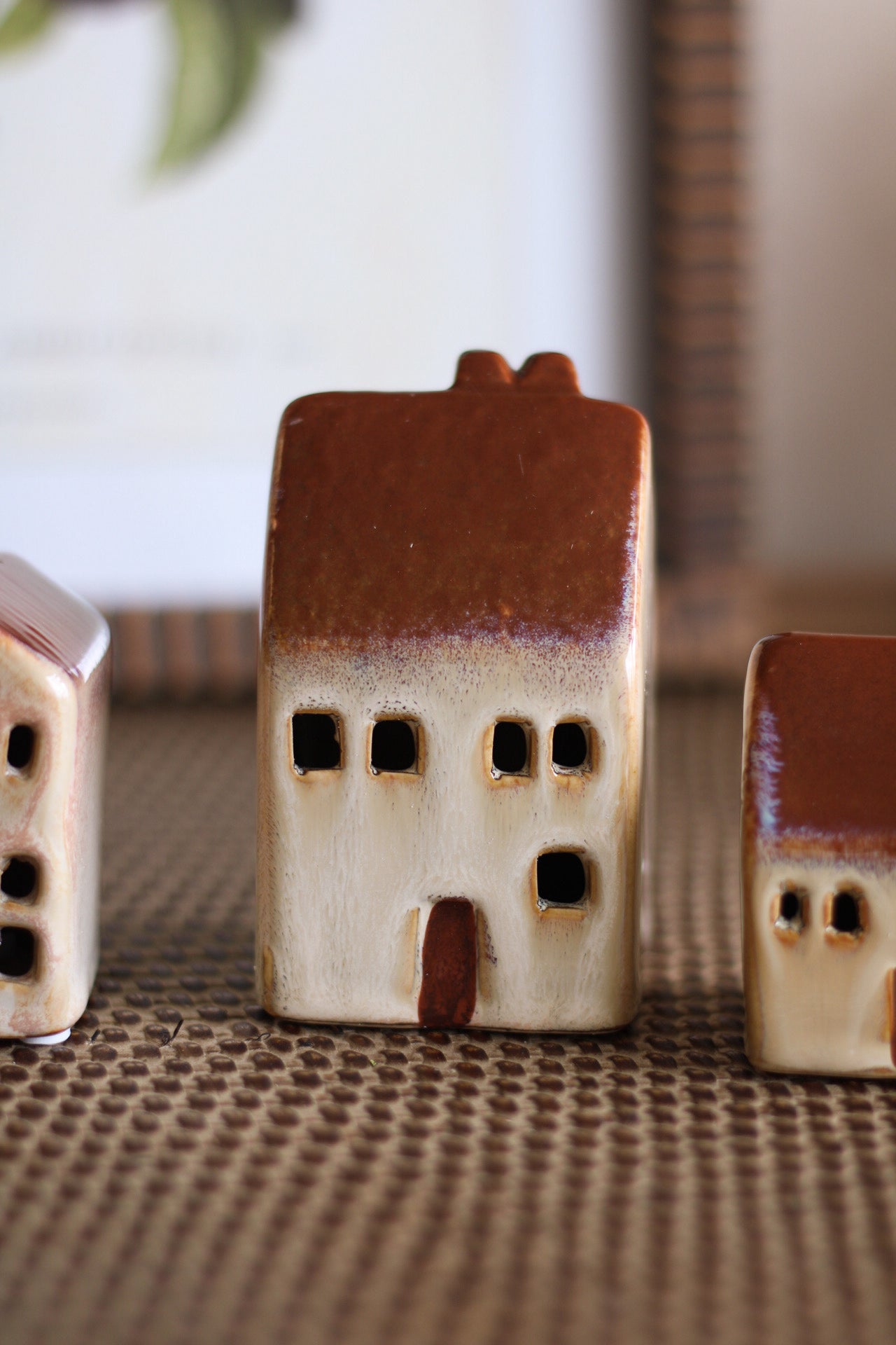 Small ceramic houses on a textured surface with a blurred background