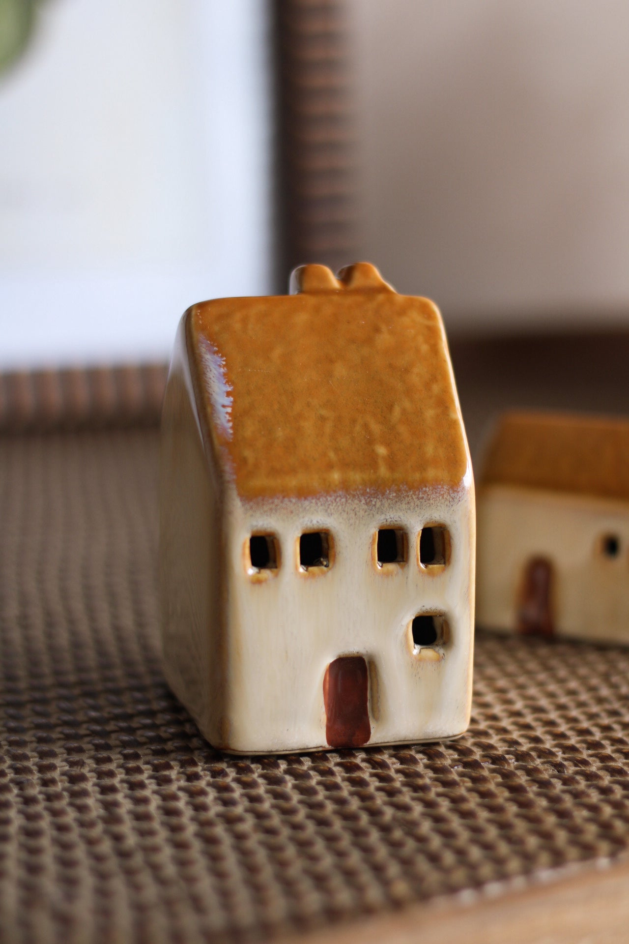 Small ceramic house figurine on a textured surface