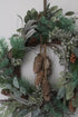 gold glittered pine cones hung on faux winter foliage wreath for christmas decor