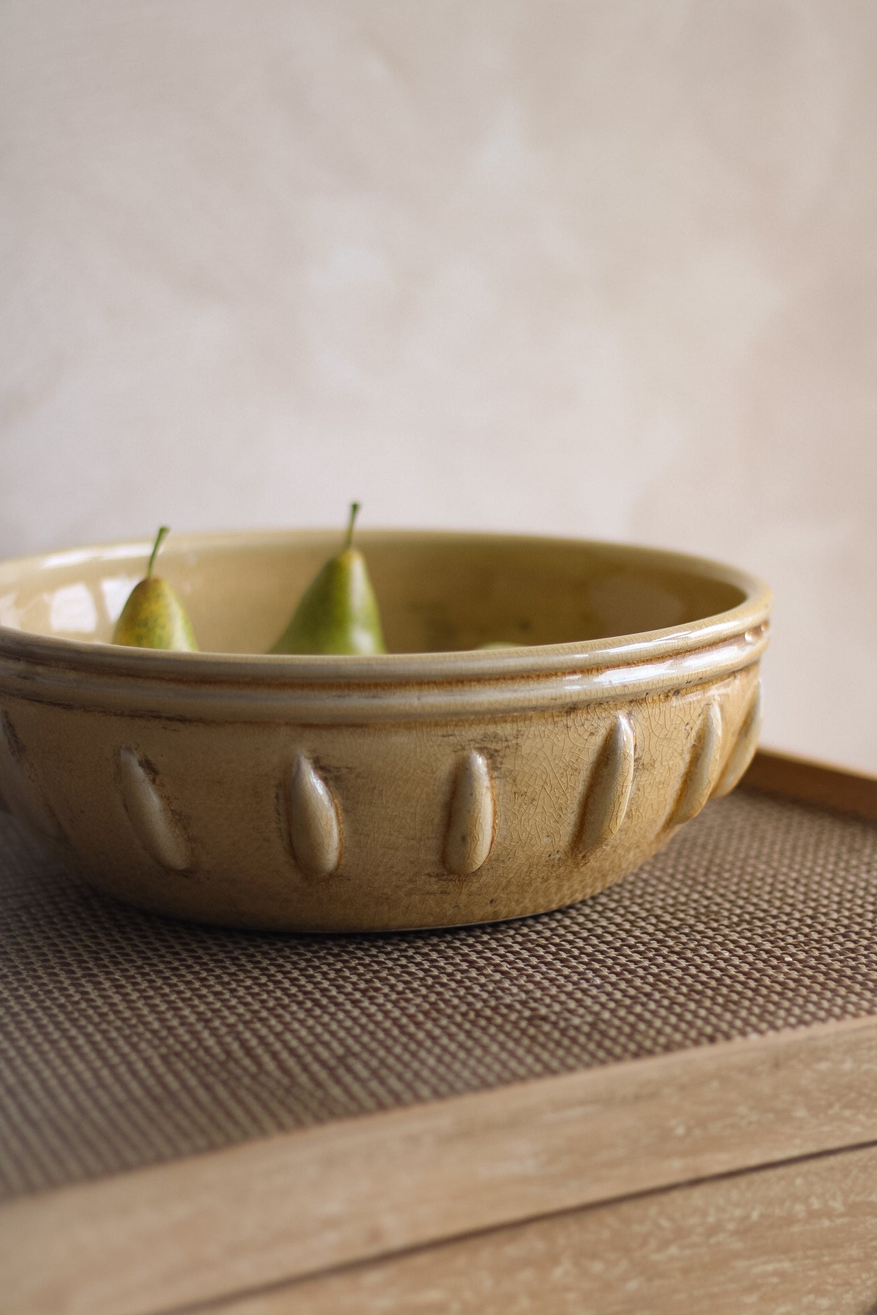 Ceramic bowl with two pears on a textured surface
