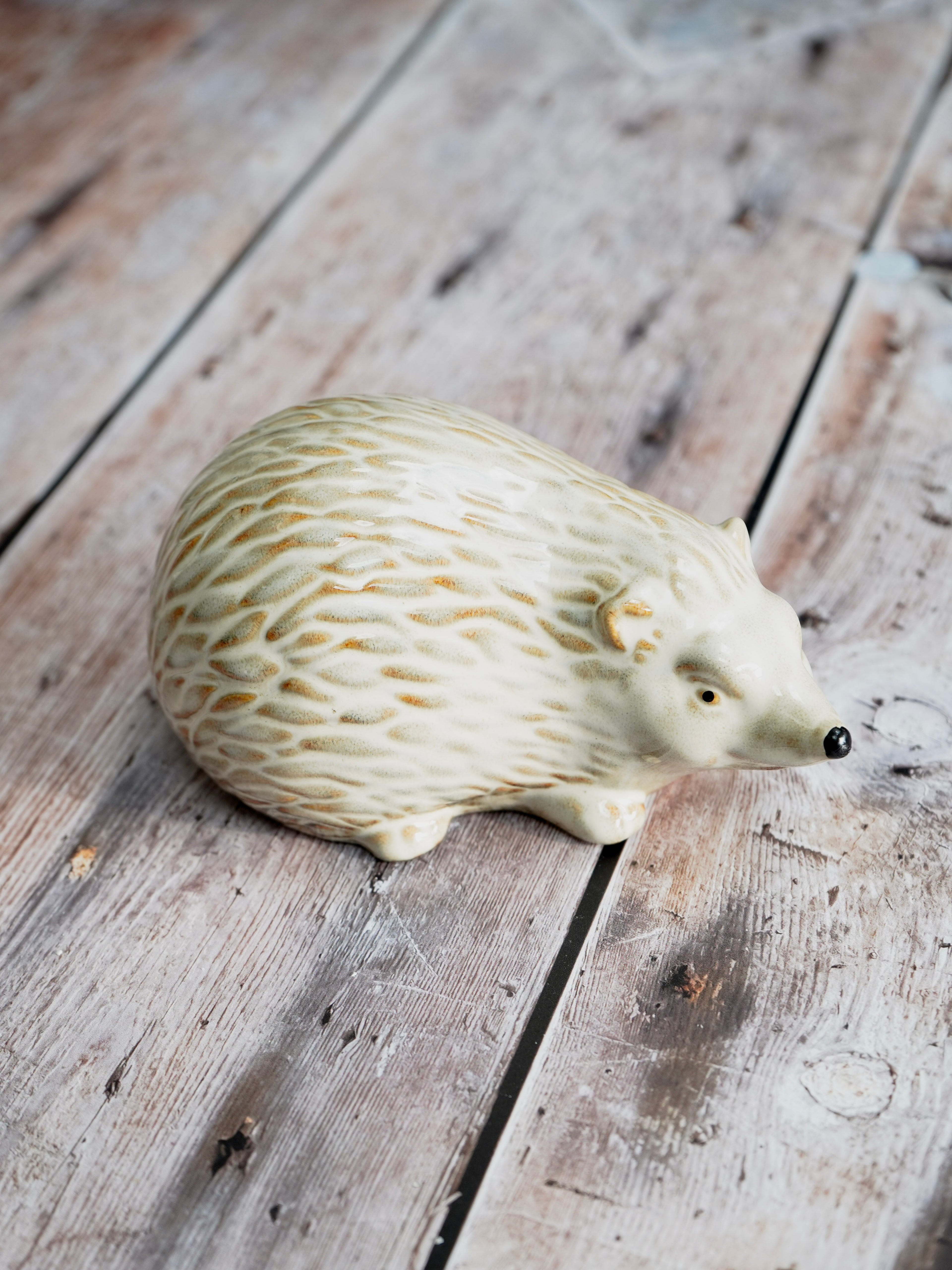 Decorative hedgehog figurine on a wooden surface