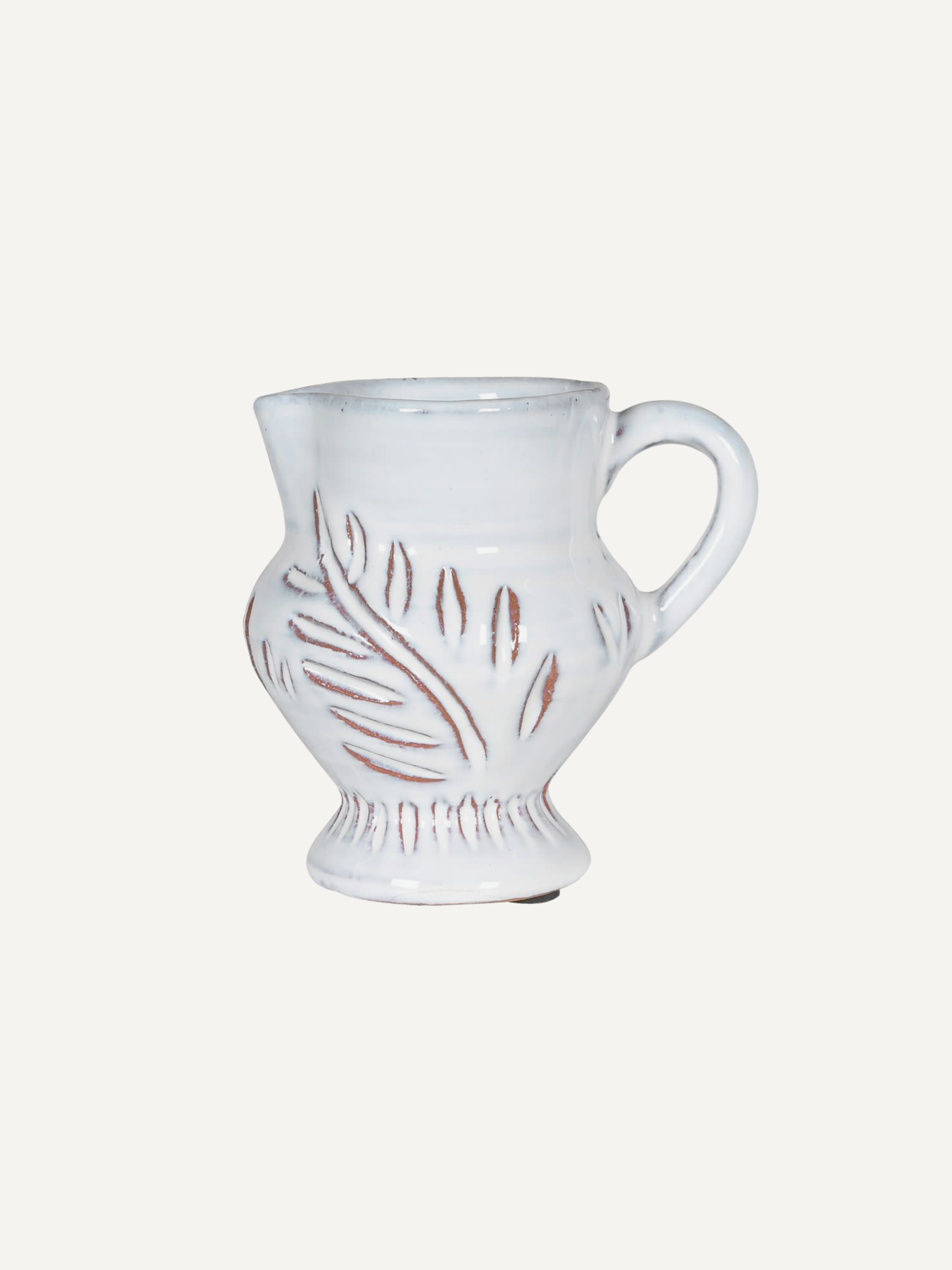 Chalk white ceramic jug with decorative leaf design on a white background, a lovely home styling piece for shelves, kitchens and styling