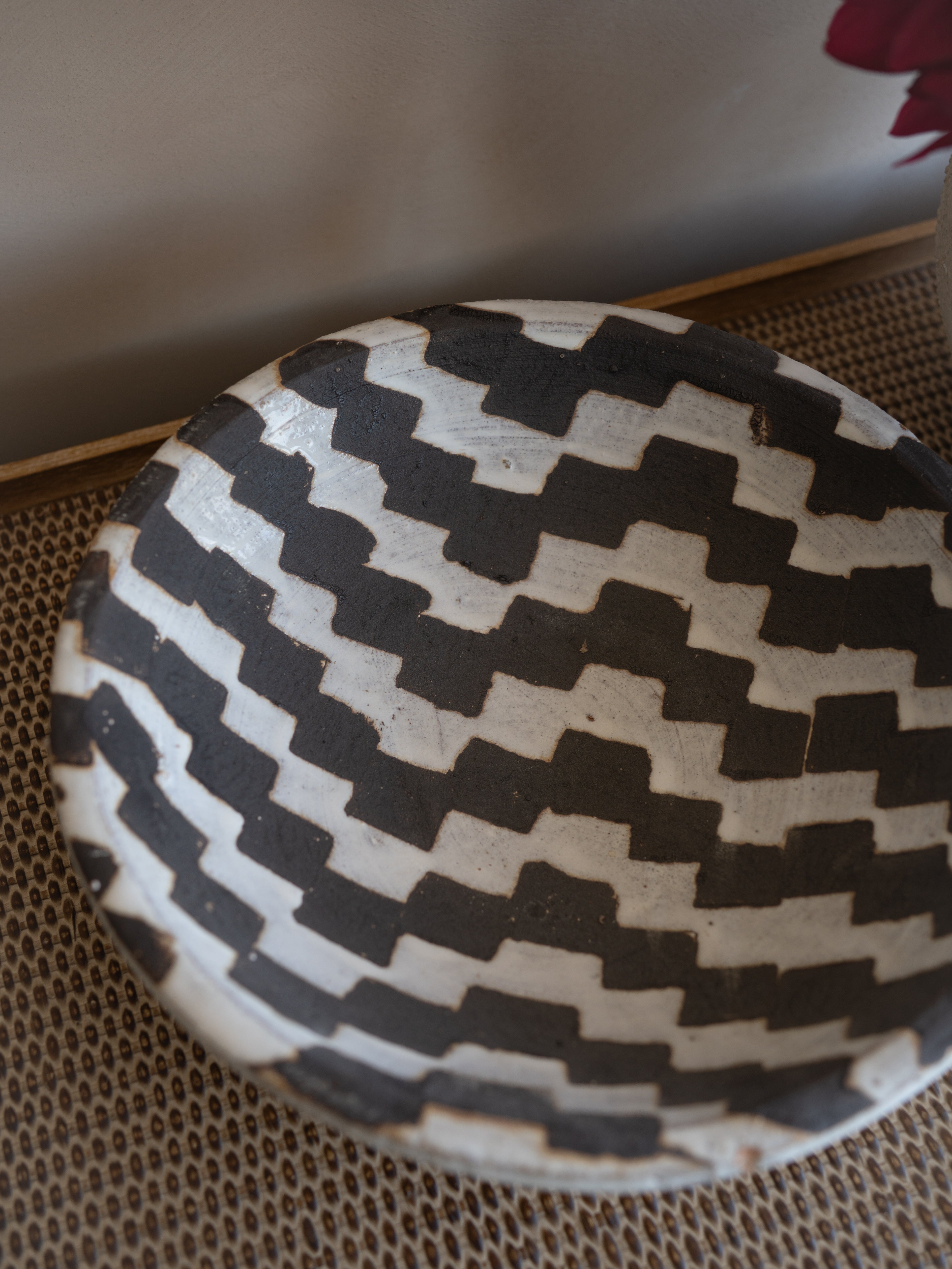 Black and white patterned ceramic decorative bowl on a textured surface