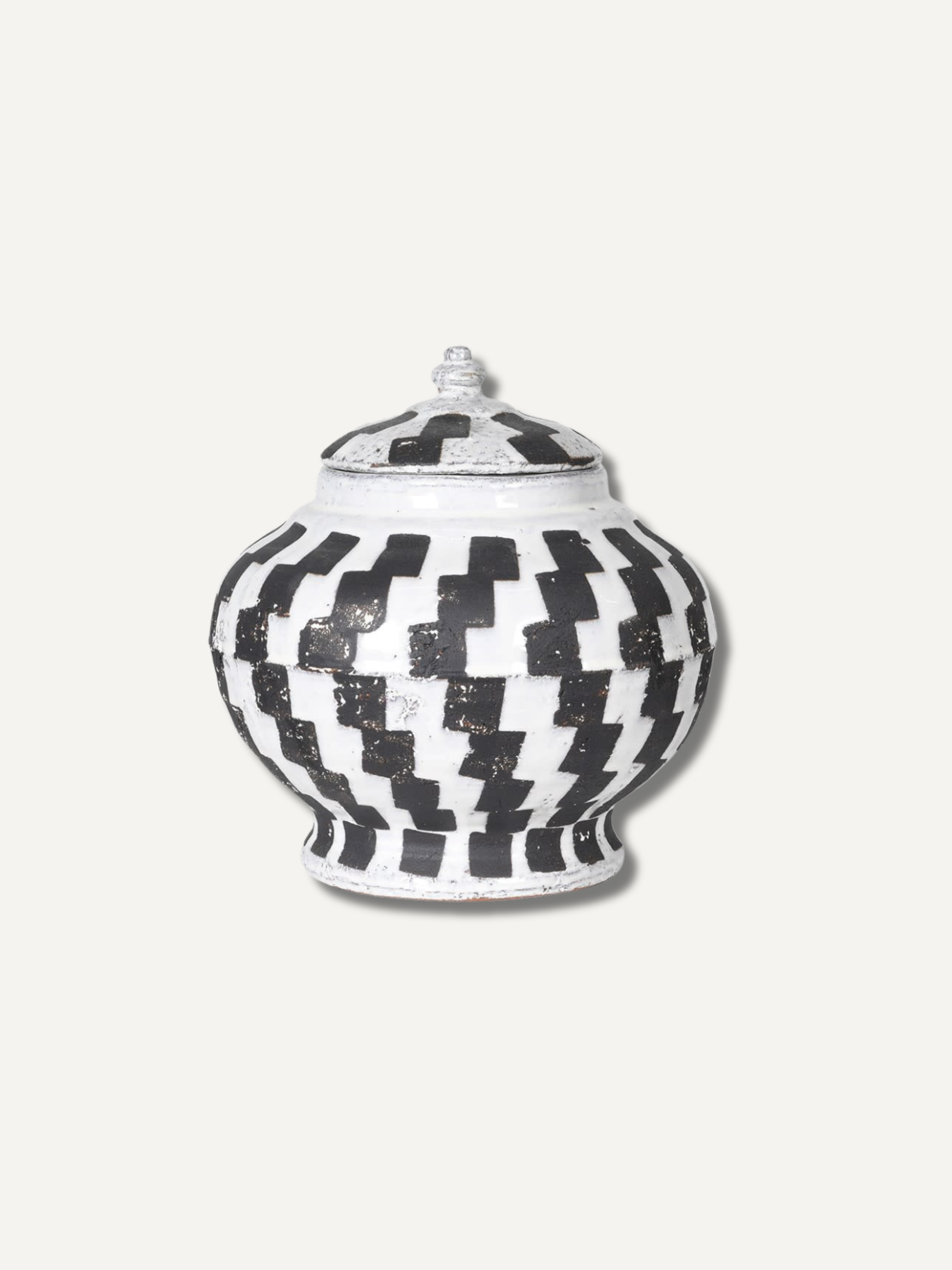 Decorative lidded jar with black and white checkered pattern on a light gray background, home styling and decor ornament