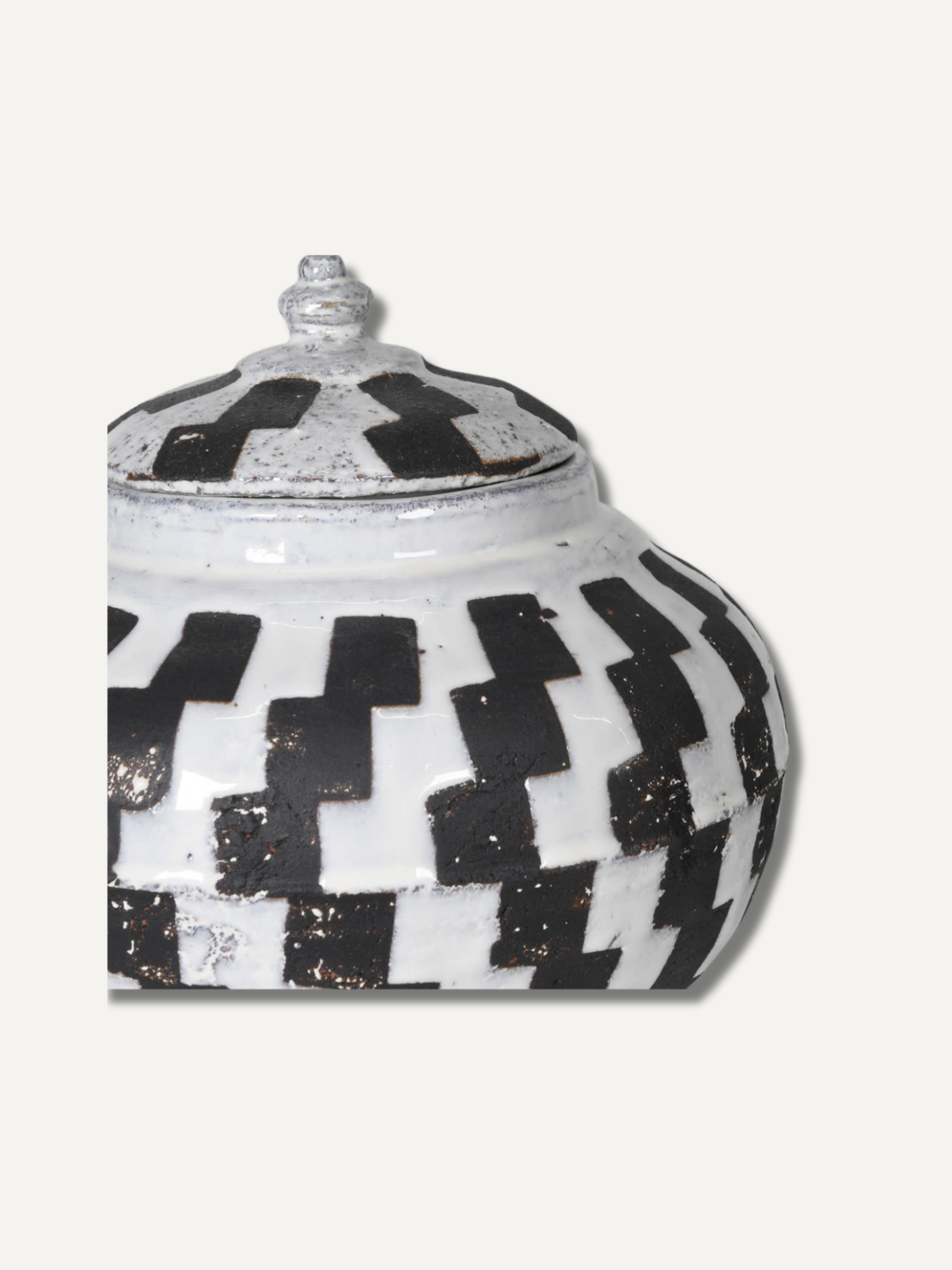 Decorative jar with black and white geometric pattern on a white background