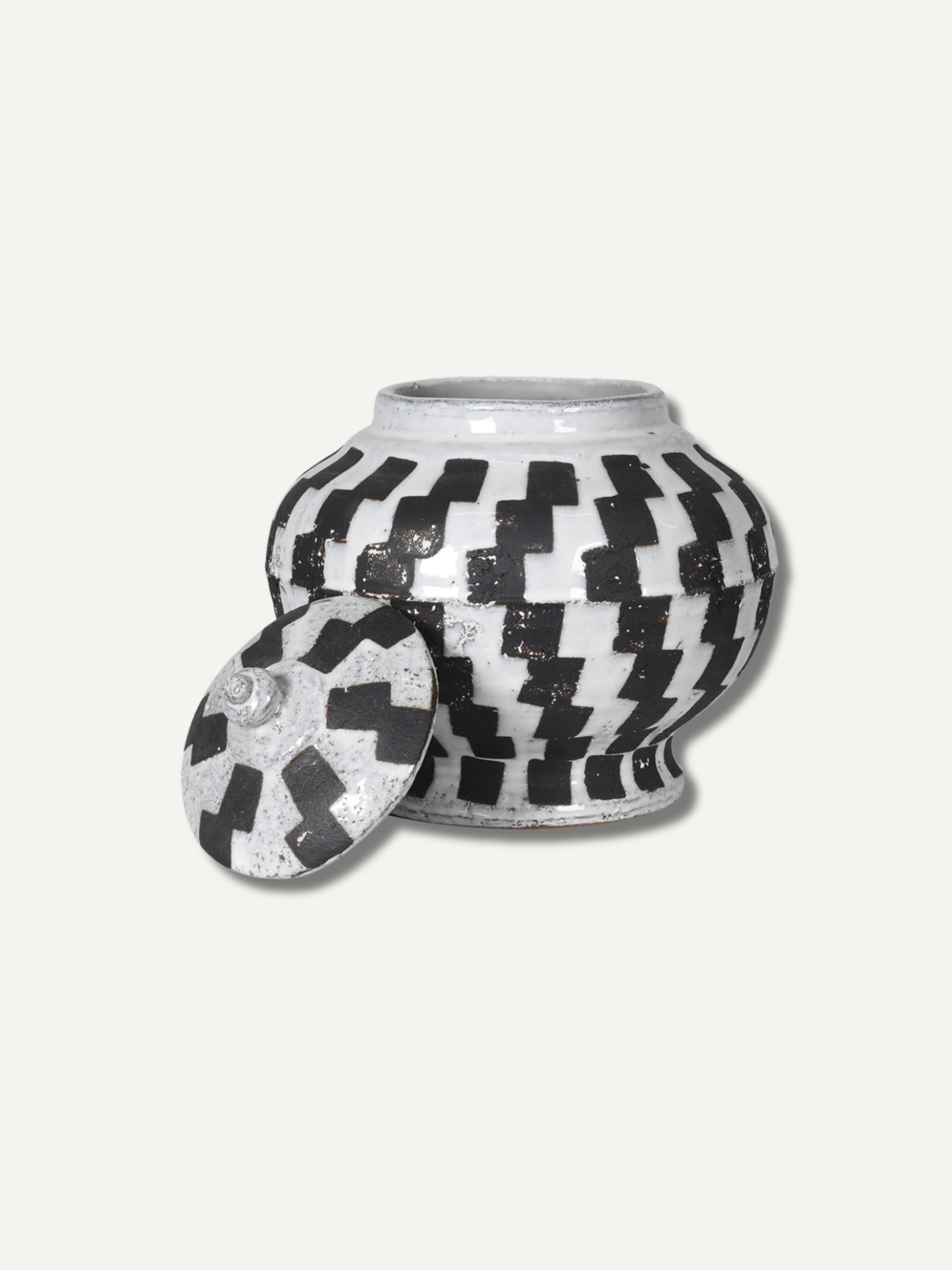 Decorative lidded jar with black and white geometric pattern on a white background for home decor styling