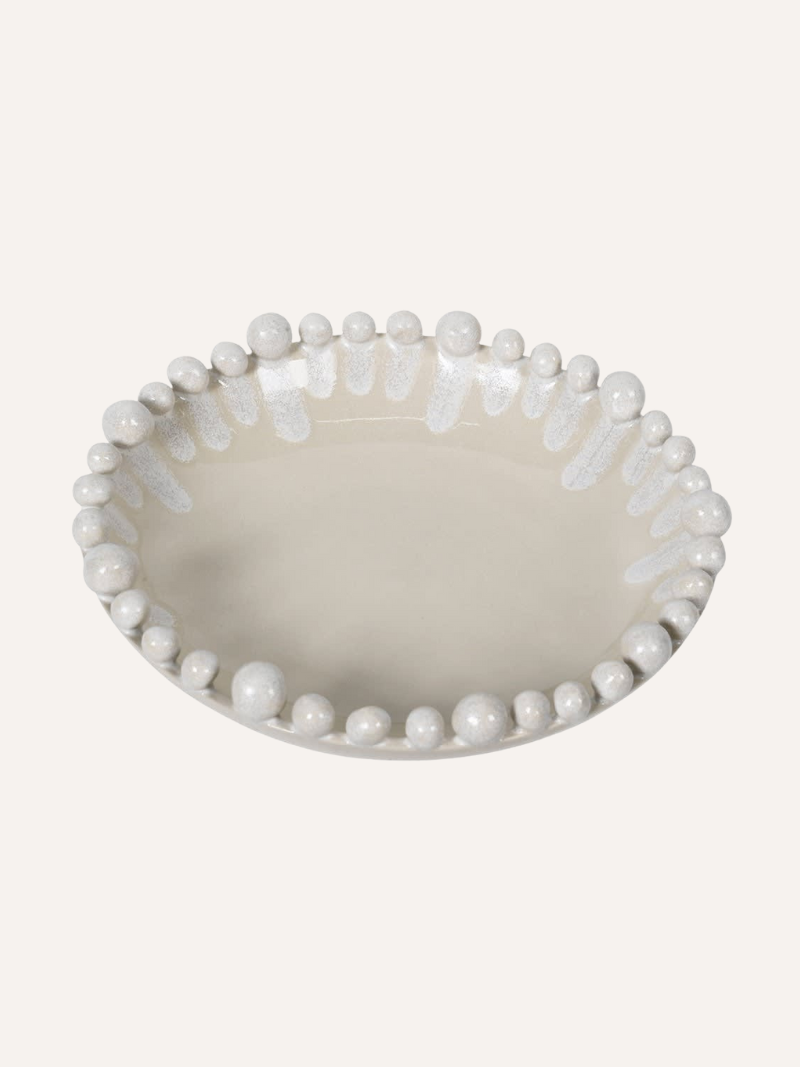 Decorative bowl with bobble-like embellishments on a white background