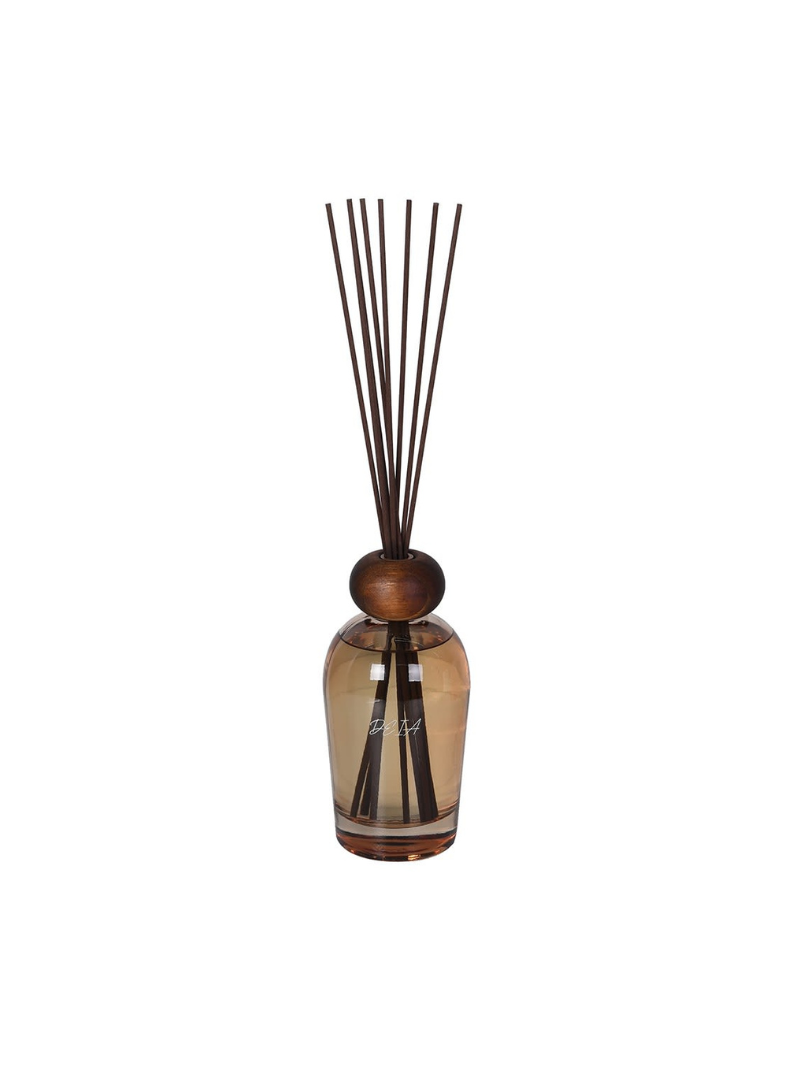 Diffuser bottle with wooden top and black sticks on a white background