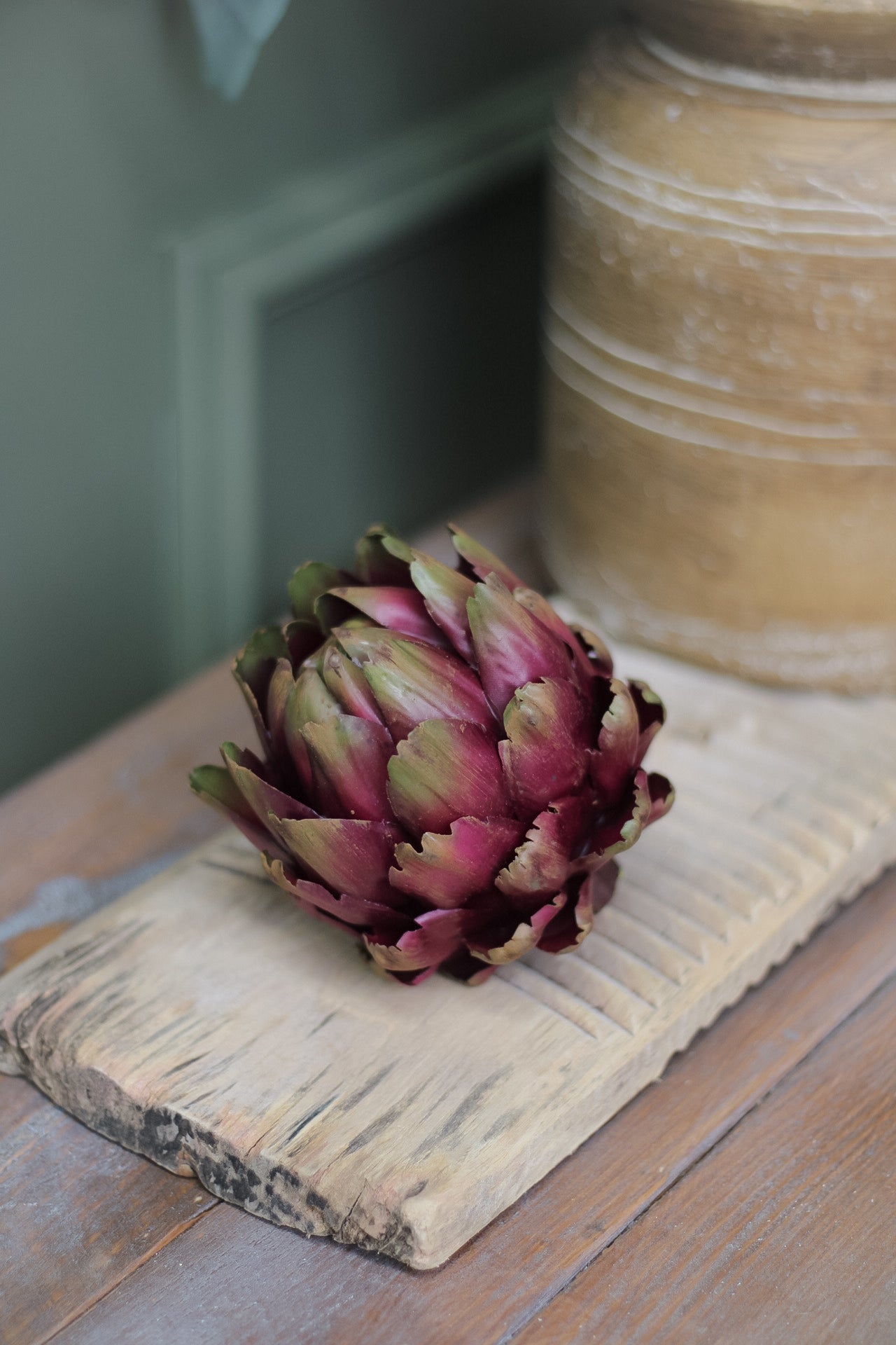 Faux purple artichoke on sideboard
