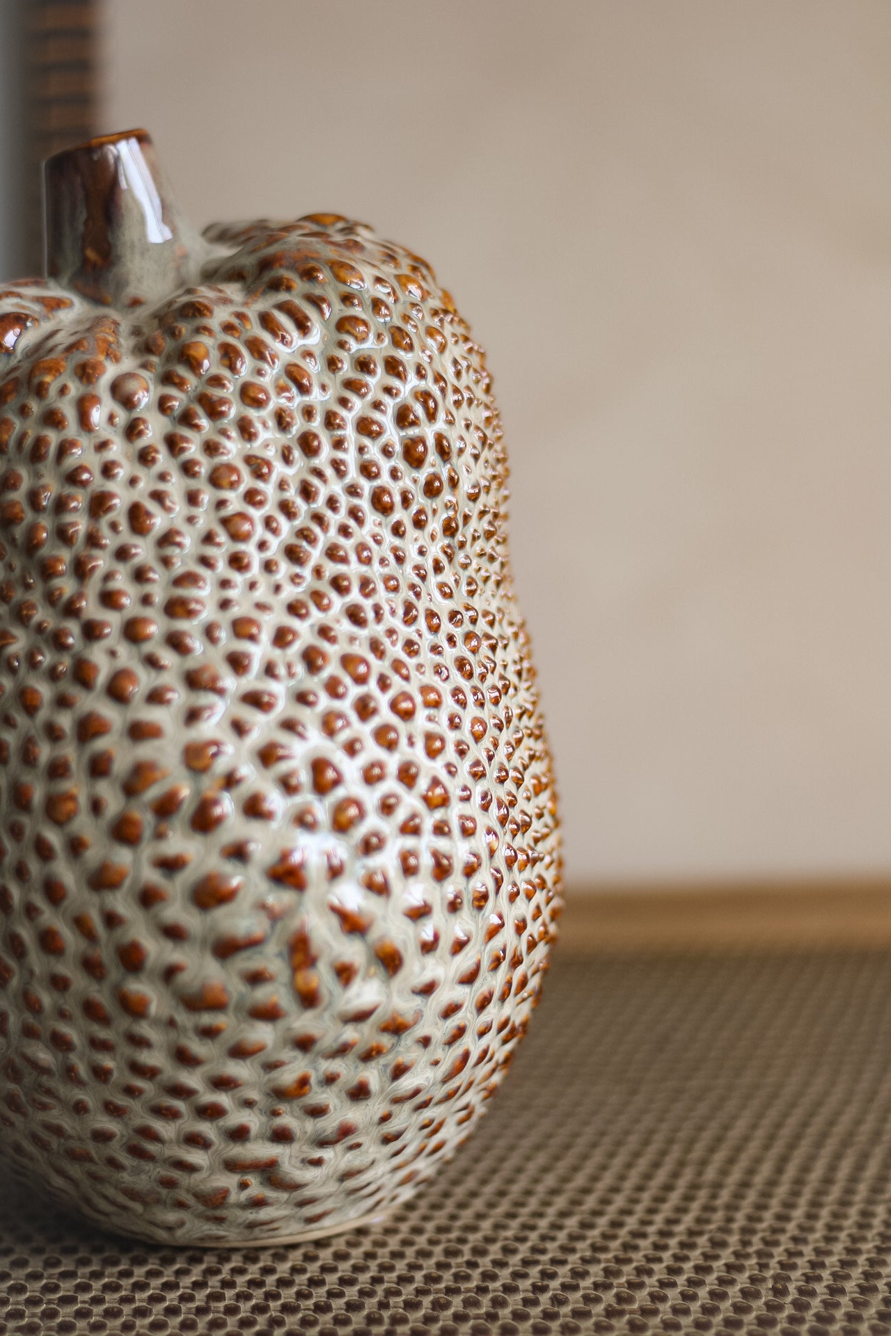 Ceramic vase with textured surface on a neutral background