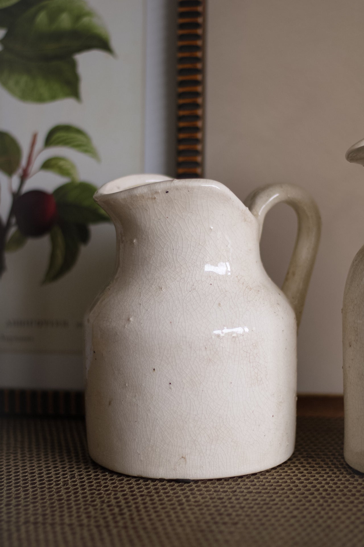 White ceramic pitcher on a textured surface with a blurred background