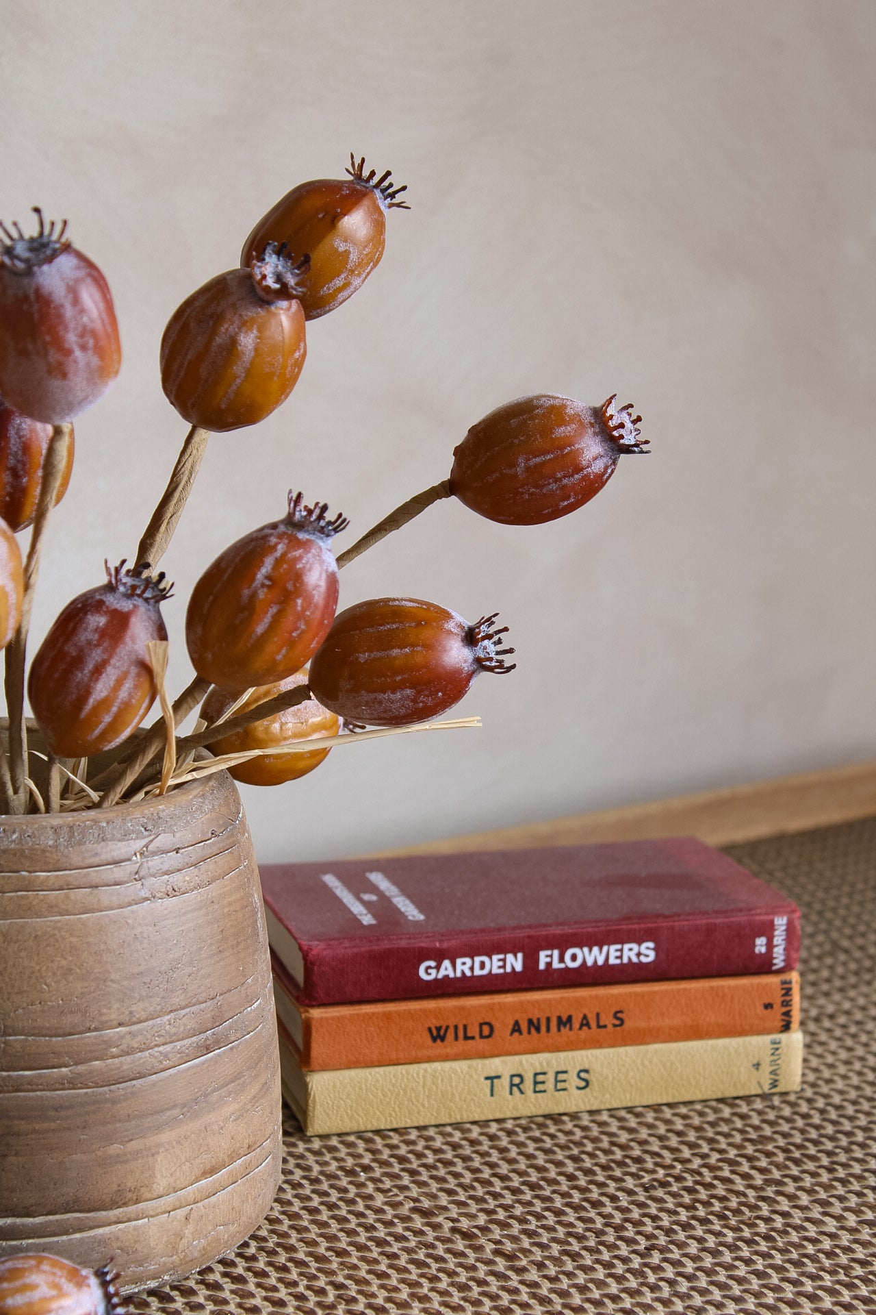 Dried flowers in a vase with books titled &