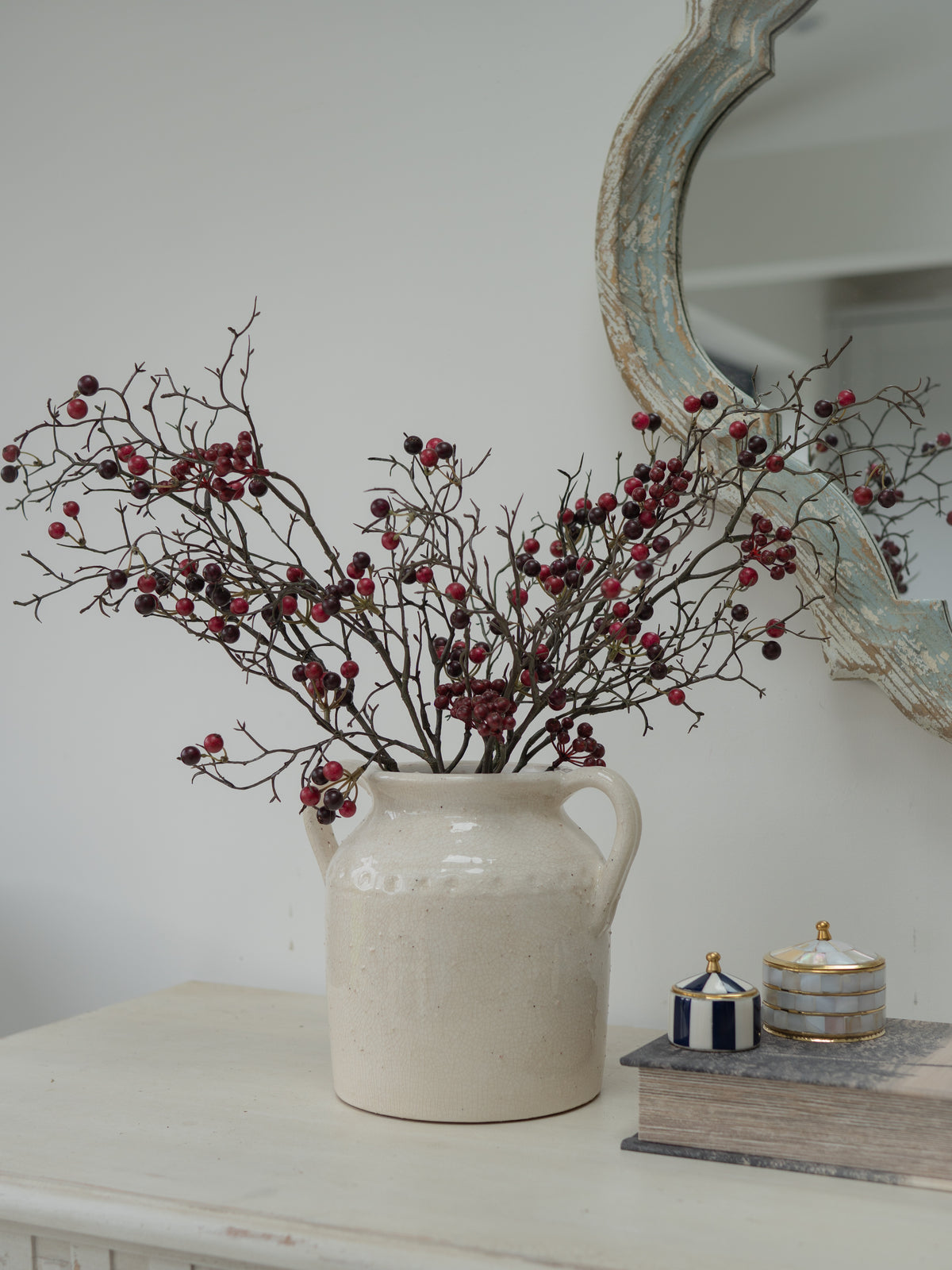 Faux Red Berries Branch in white ceramic vase with handles