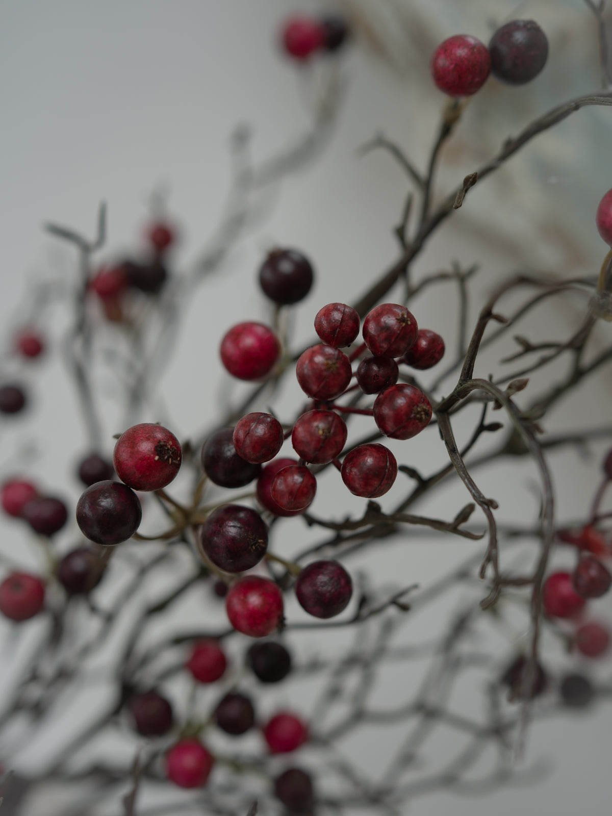 cluster of faux red berries on branch