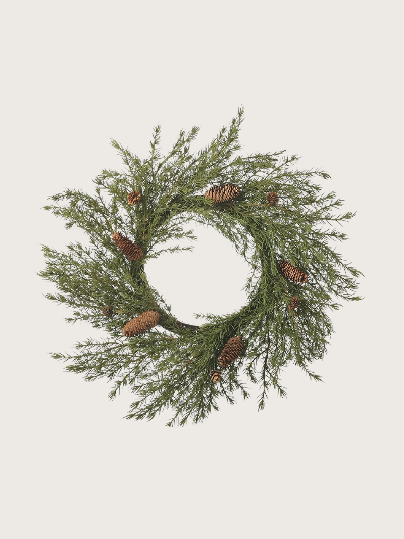 faux christmas foliage wreath with pinecones on a light gray background