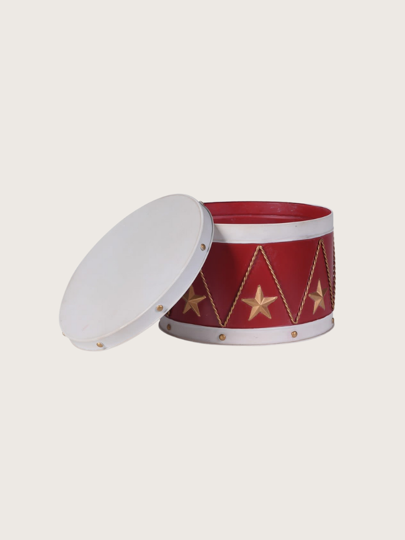 Red cylindrical tin with white lid and gold star patterns on a light gray background