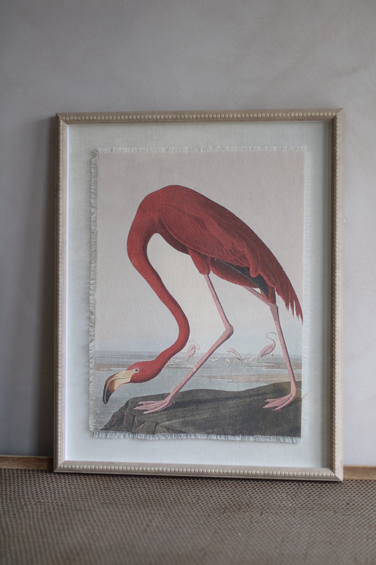 Framed artwork of a flamingo on a neutral wall.