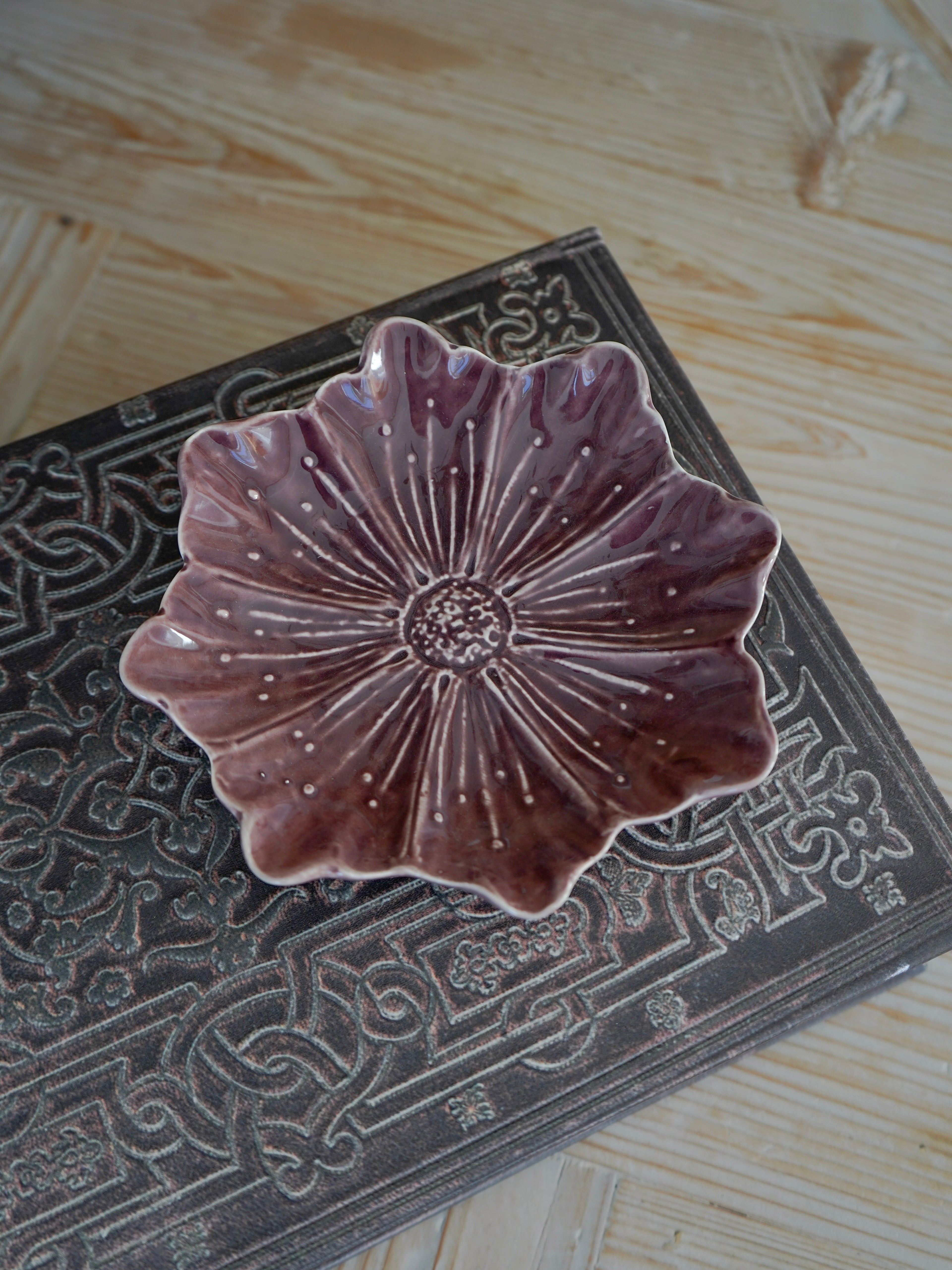 Decorative ceramic plate with floral design on a textured surface