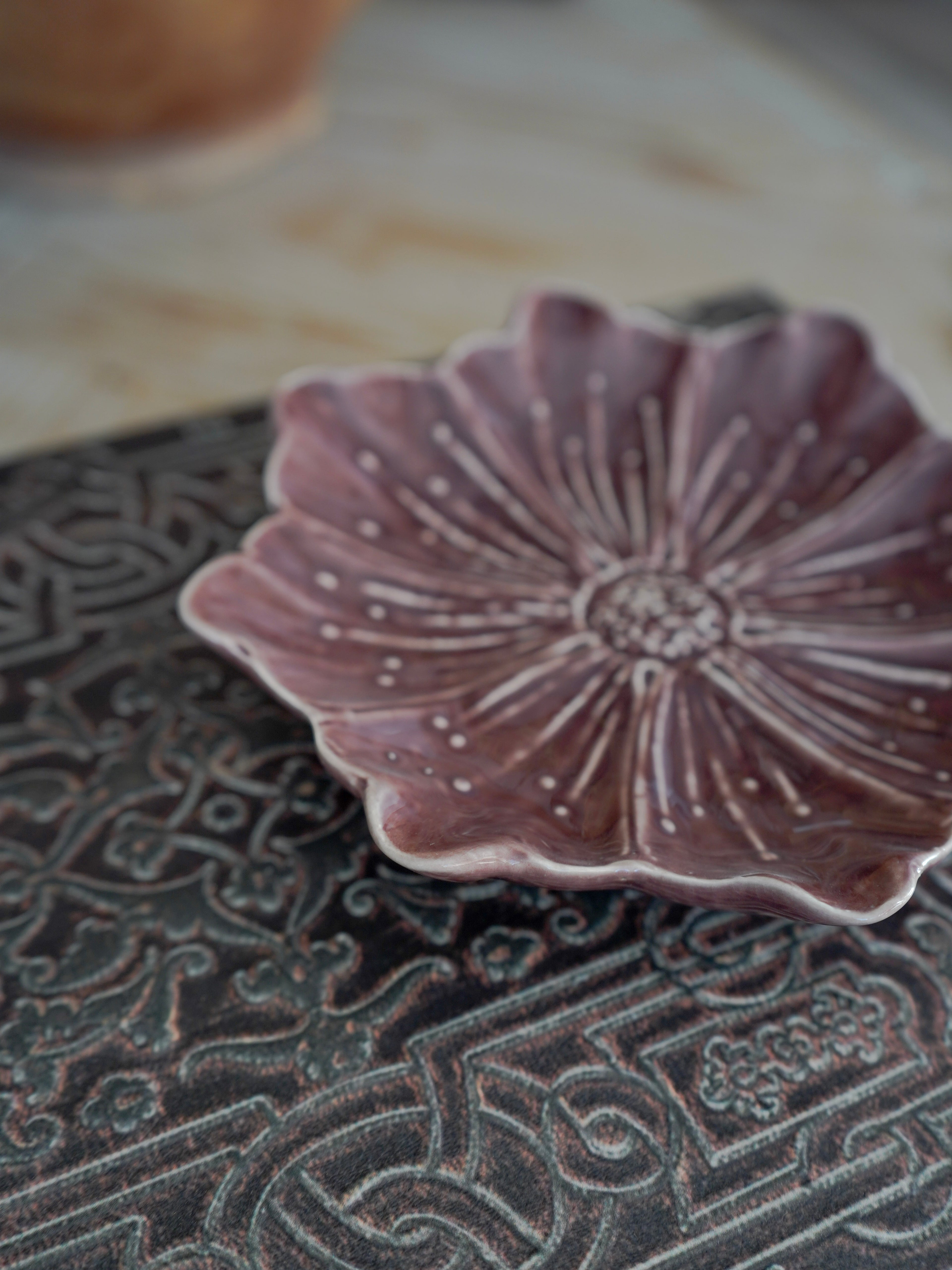 Ceramic dish with floral design on a textured surface