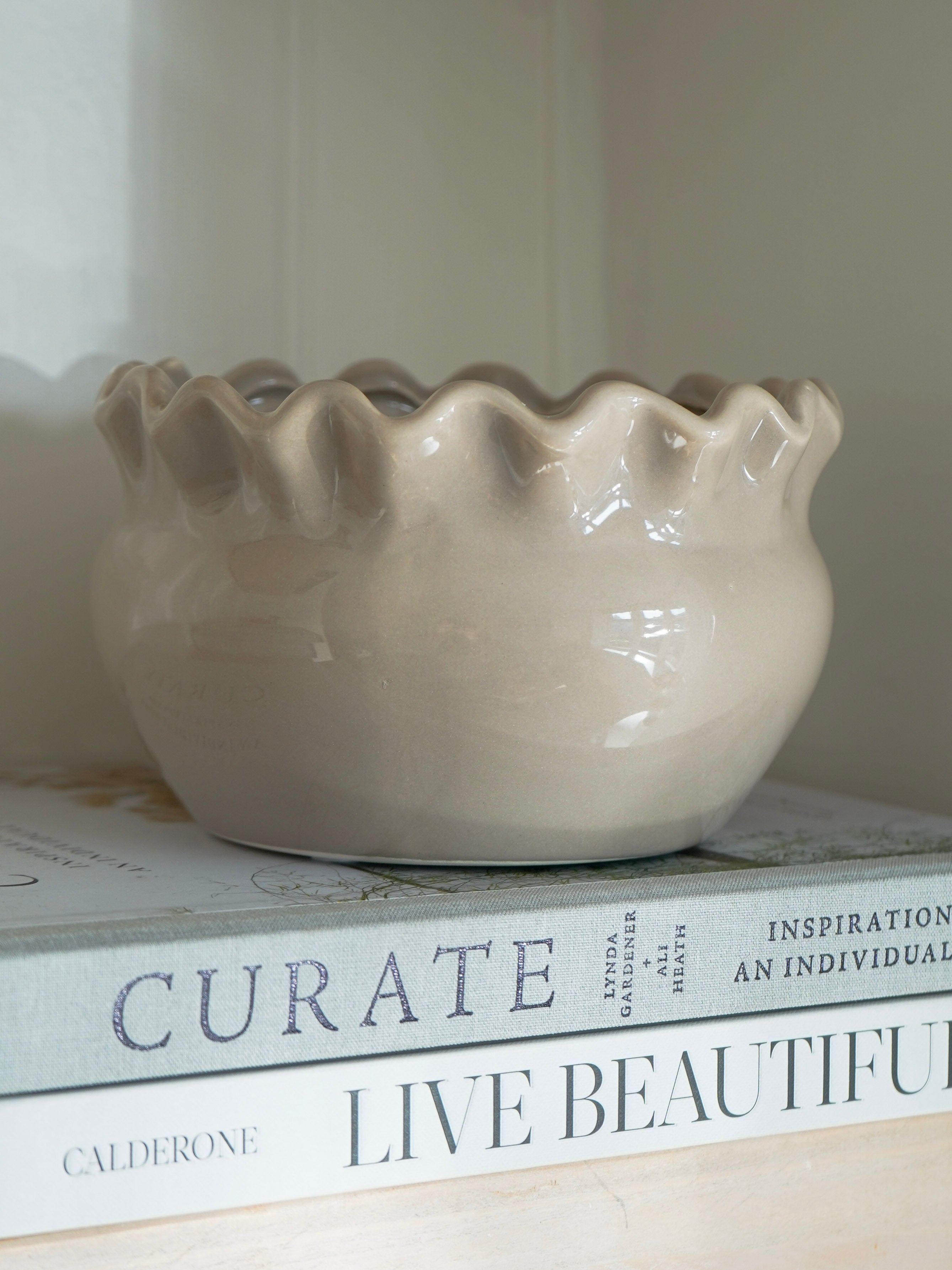 Beige ceramic bowl on top of books with visible text