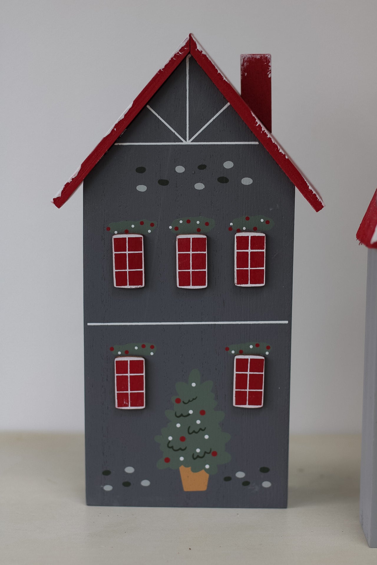 charcoal grey wooden chunky christmas block house with christmas tree and garlands over the windows