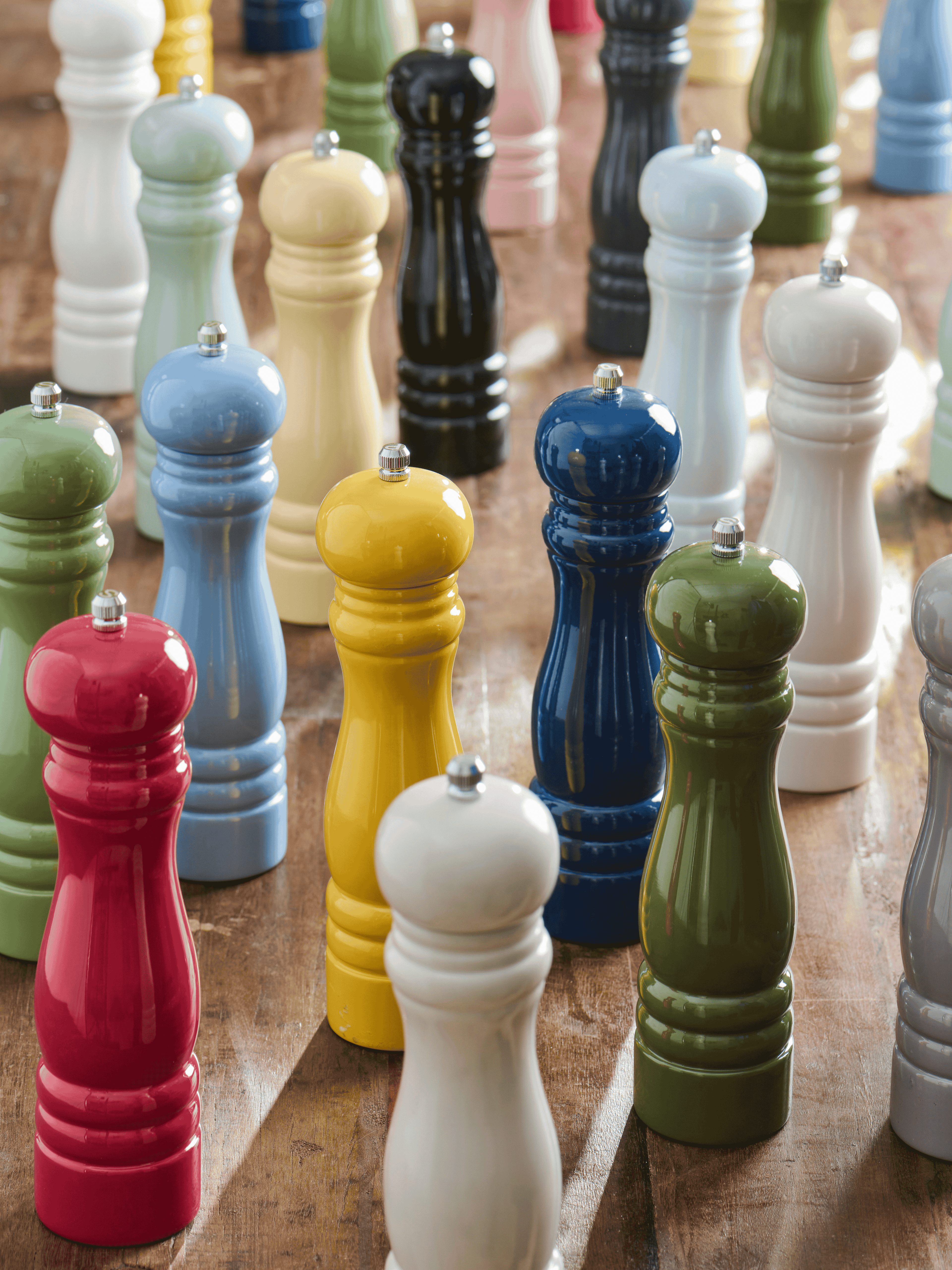 Colorful collection of salt and pepper mills on a wooden surface