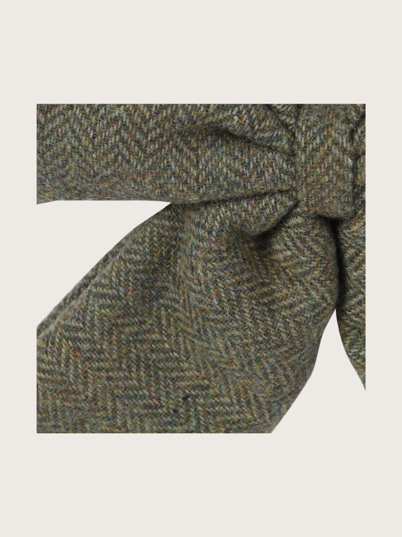 Green herringbone patterned tie on a light gray background