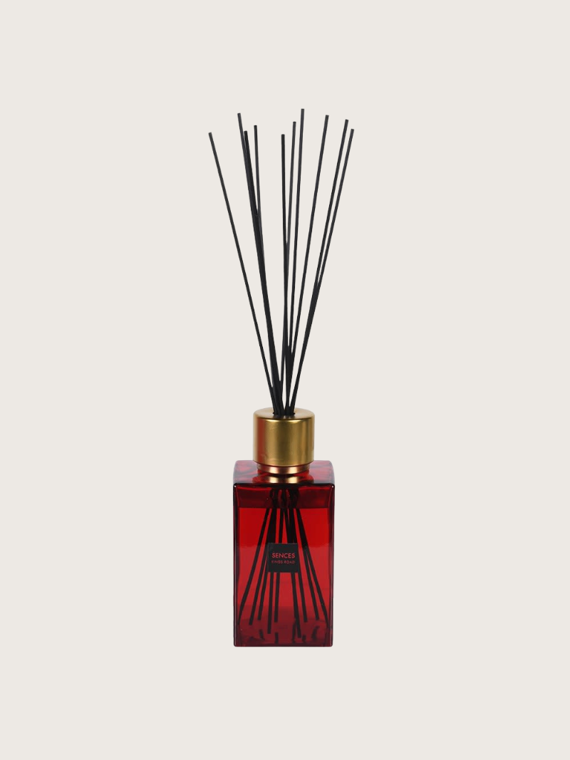 Red kings road sences diffuser bottle with black sticks on a light gray background