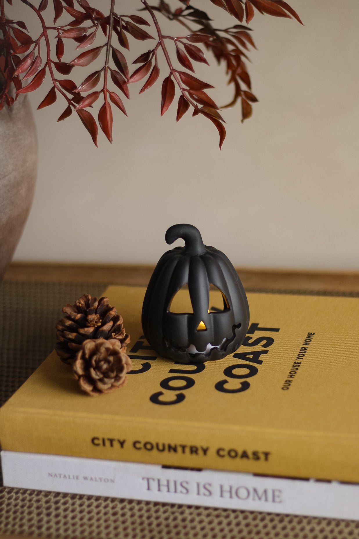 Black pumpkin decoration on a book titled &