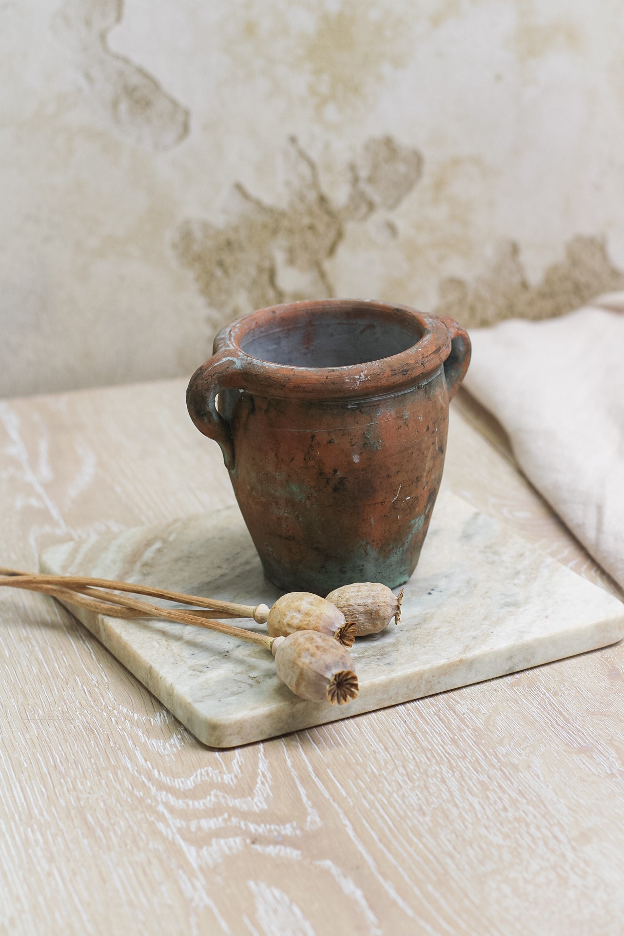 mini vintage olive pot on beige marble tray with dried poppy heads