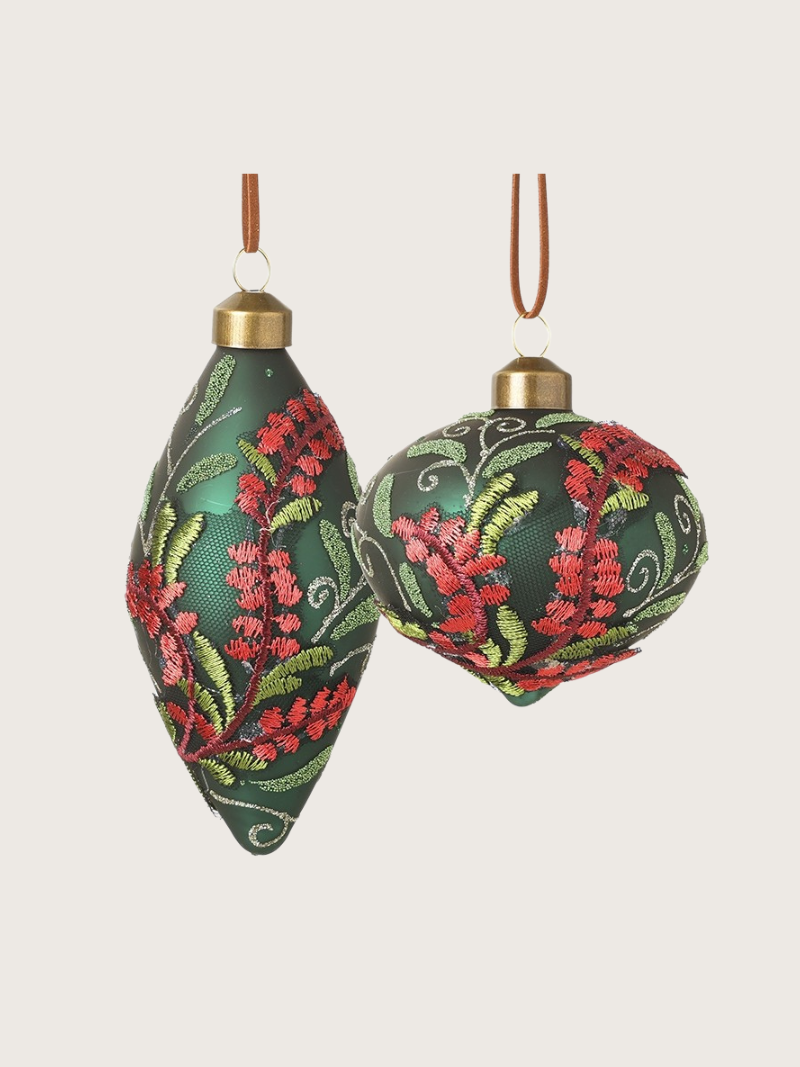 Two decorative Christmas ornaments with floral patterns on a light beige background