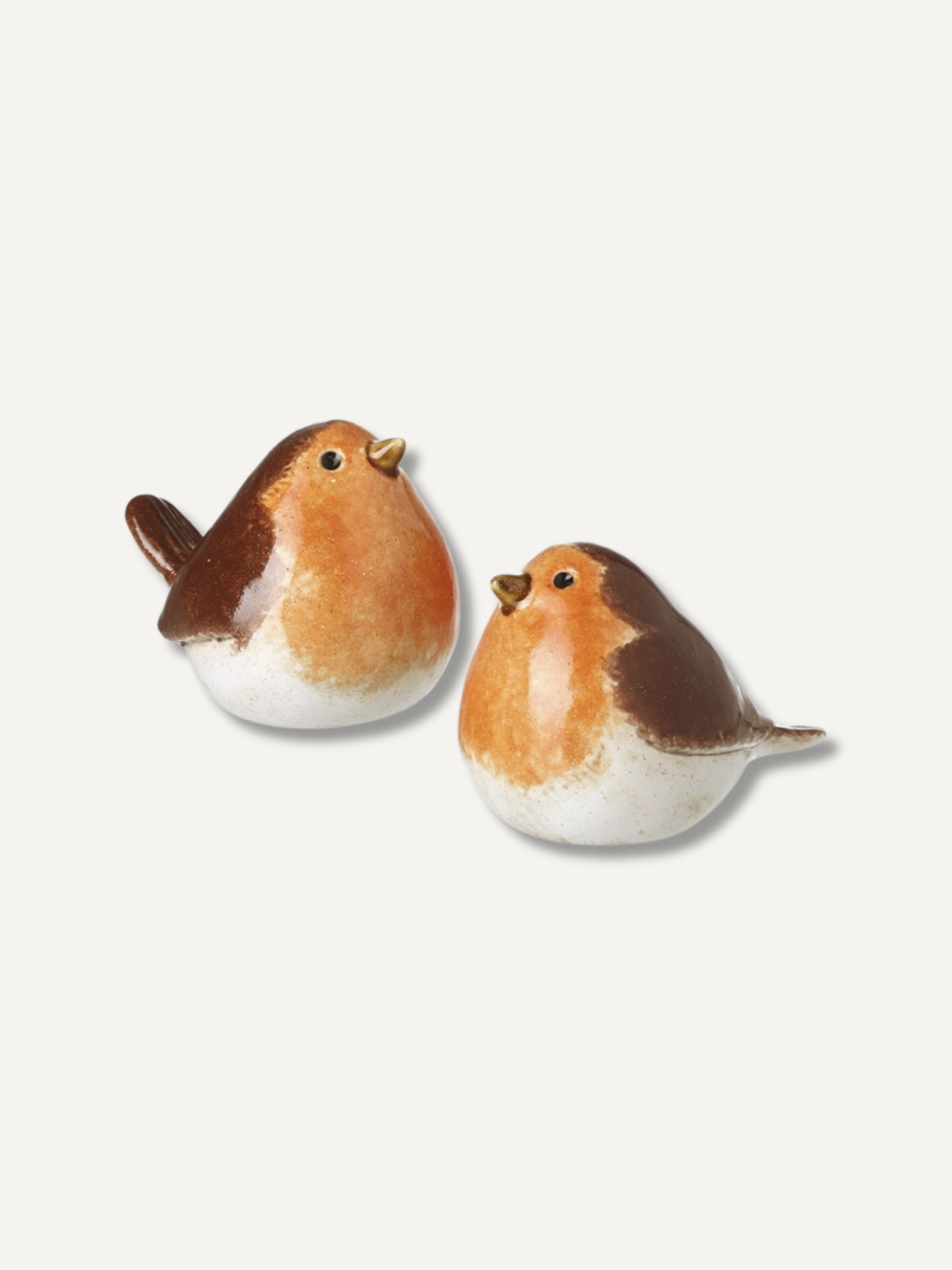 Two small robin bird figurines with brown backs, orange bellies, and white underbellies, shown on a plain light gray background.