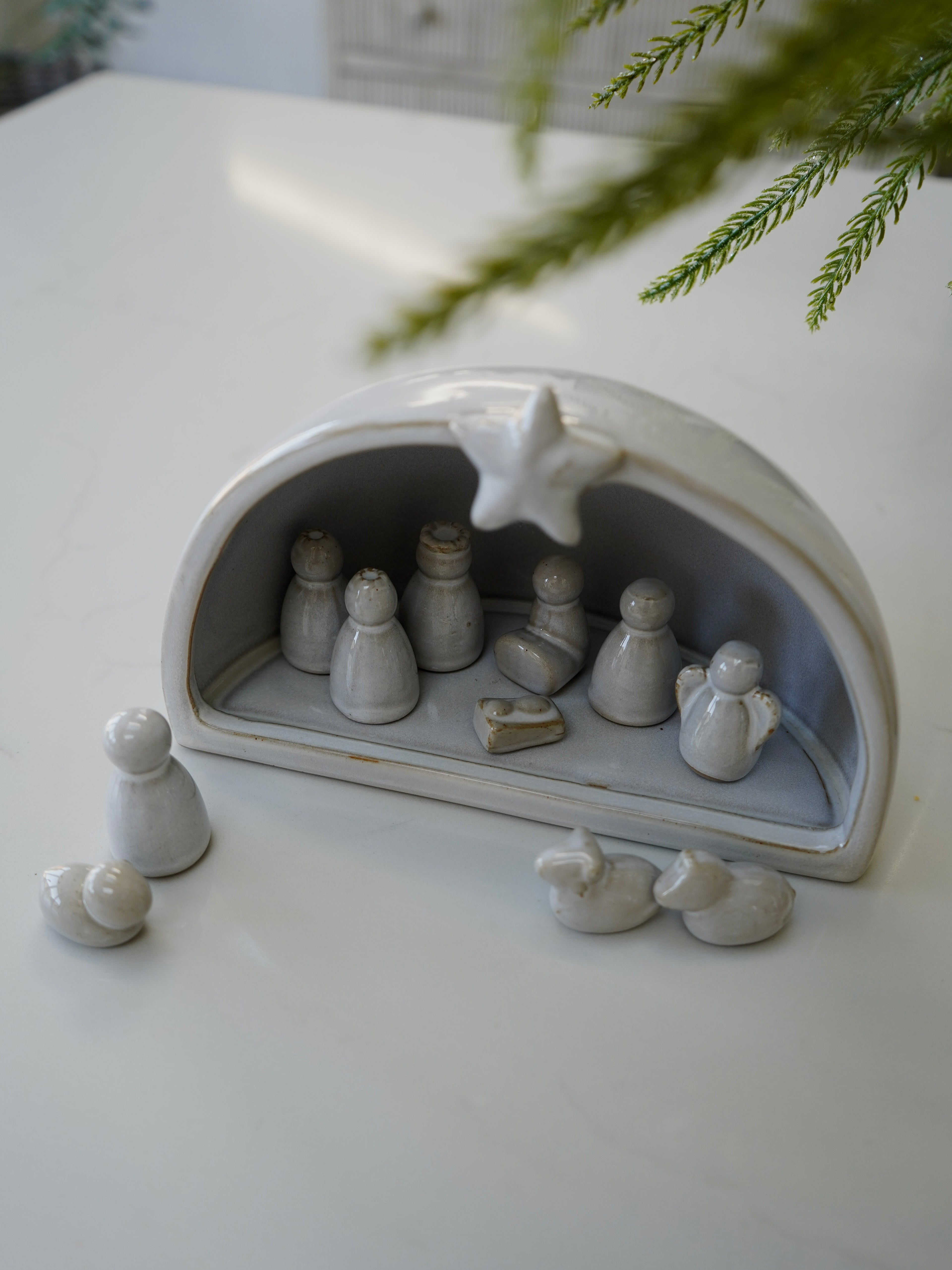 Ceramic nativity scene with figures on a white surface